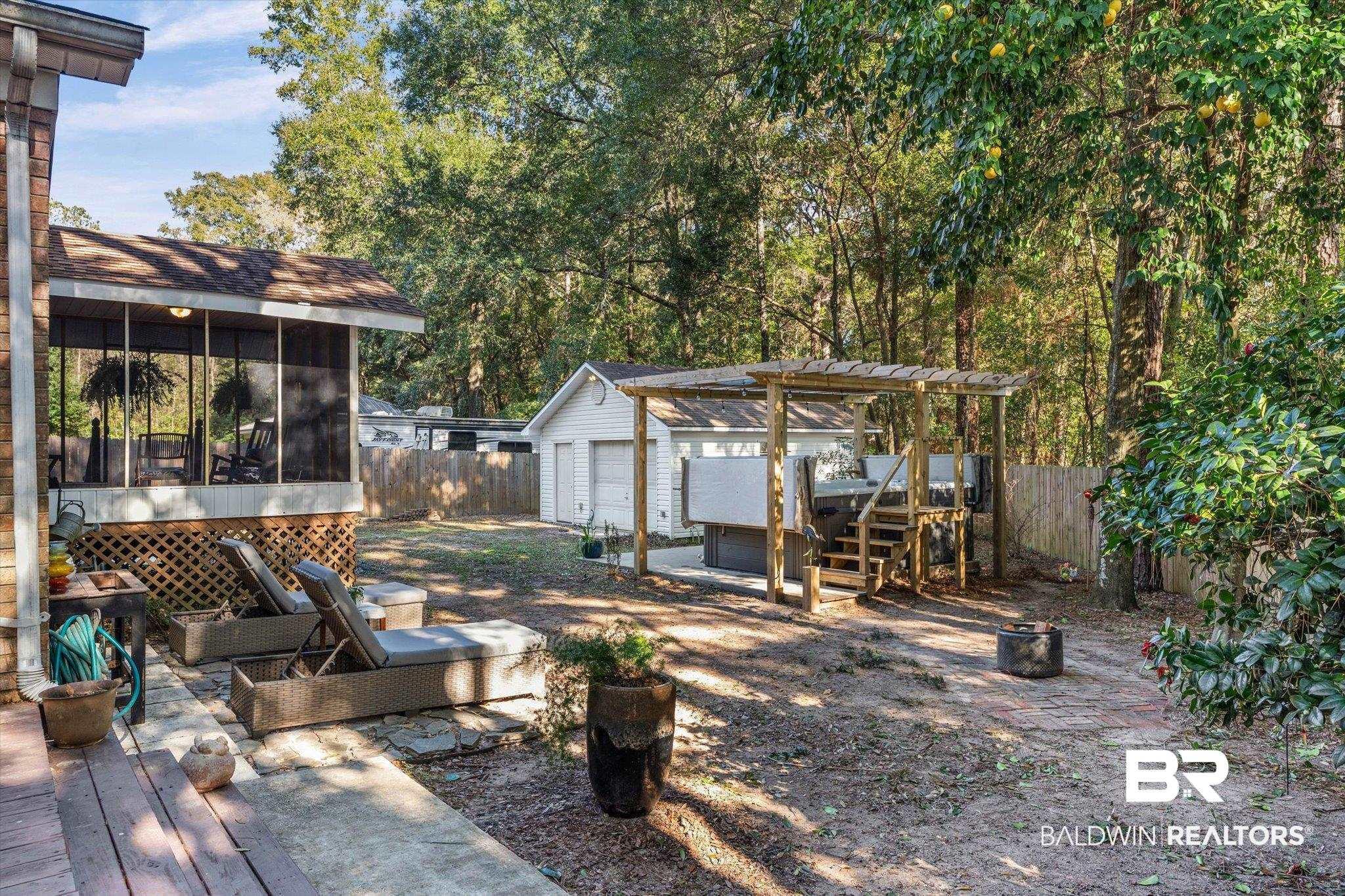 Image 3: Fenced backyard with an outbuilding, a deck, a sunroom, and a patio