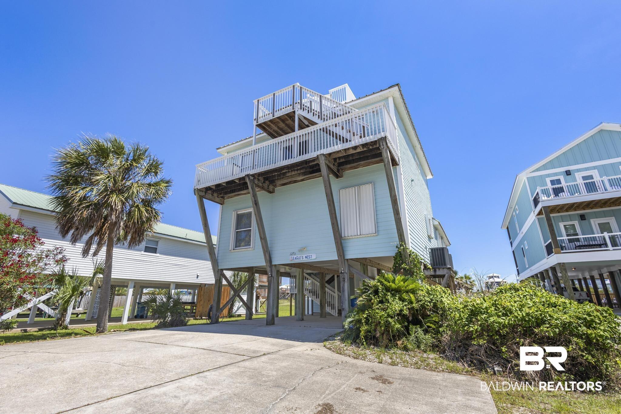 Image 3: Coastal inspired home featuring a carport and concrete driveway