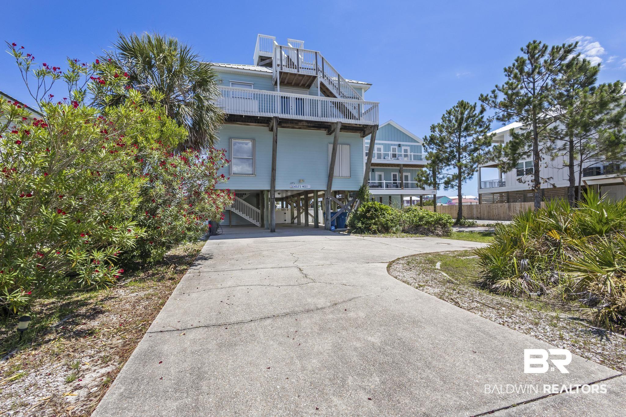Image 4: Rear view of house featuring a carport, concrete driveway, and a wooden deck