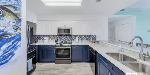 Image 3: Kitchen with tasteful backsplash, white cabinets, sink, appliances with stainless steel finishes, and light hardwood / wood-style flooring