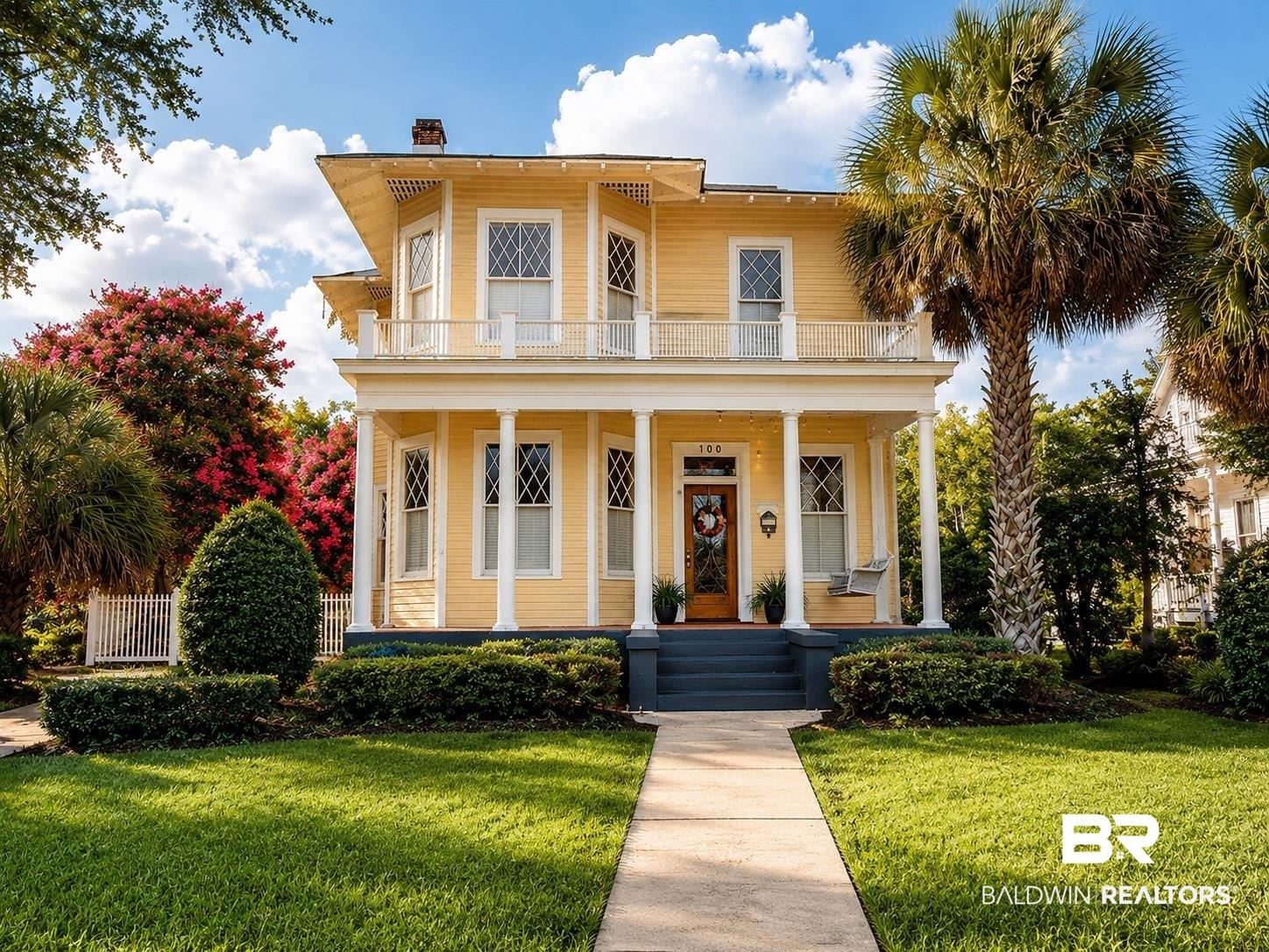 Image 1: Two-story traditional residence with a yellow exterior and white trim
