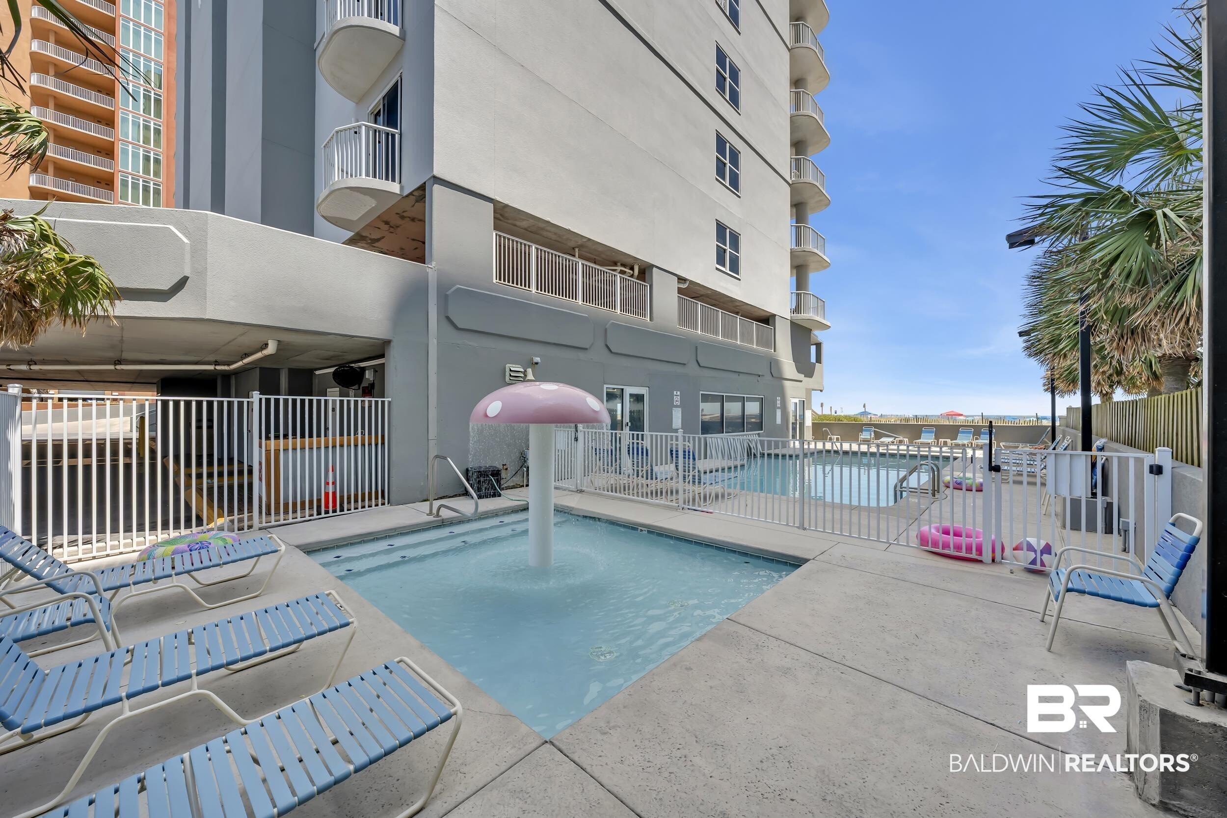 Image 4: Outdoor pool area featuring a mushroom-shaped water feature, concrete decking, and multiple lounge chairs