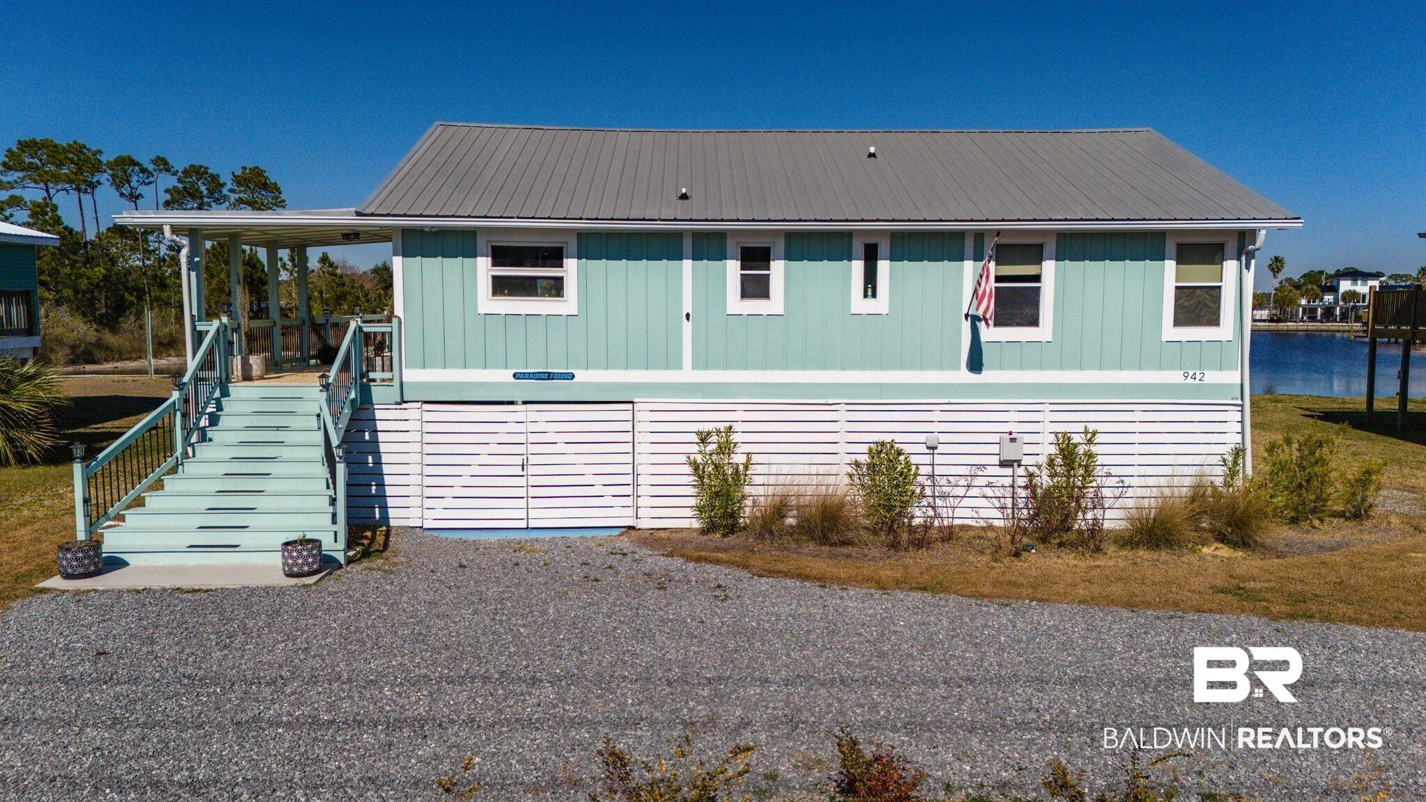 Image 2: View of front of home with a metal roof and board and batten siding