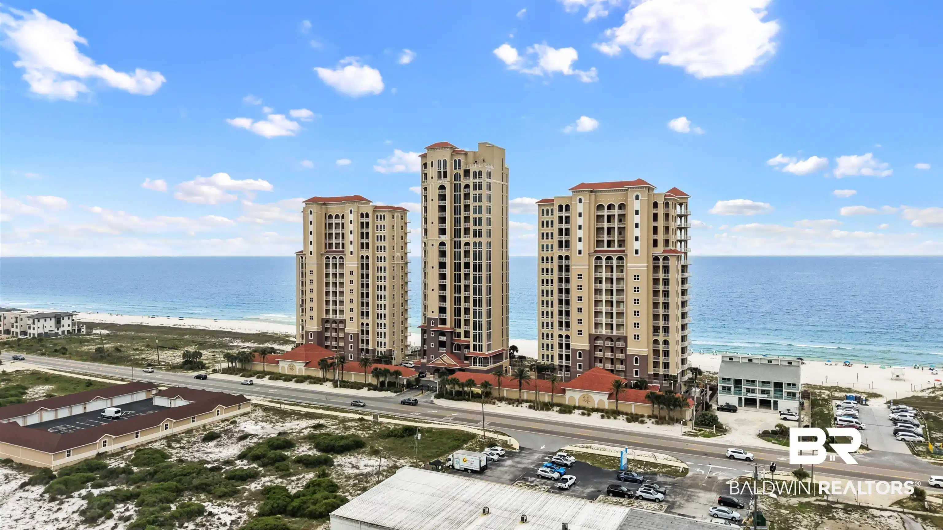 Image 1: Beachfront high-rise condominiums featuring multiple balconies and a terracotta-style roofline