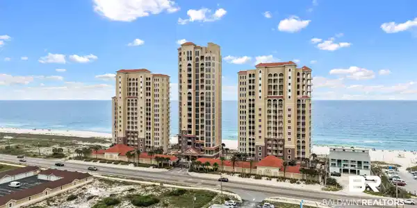 Image 2: Coastal high-rise property featuring multiple towers with Mediterranean-inspired architecture, terracotta roof tiles, and extensive balcony access