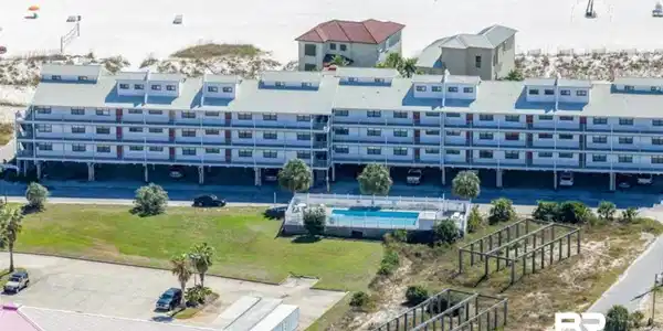 Image 2: Multi-story condominium building featuring a white facade and individual balconies