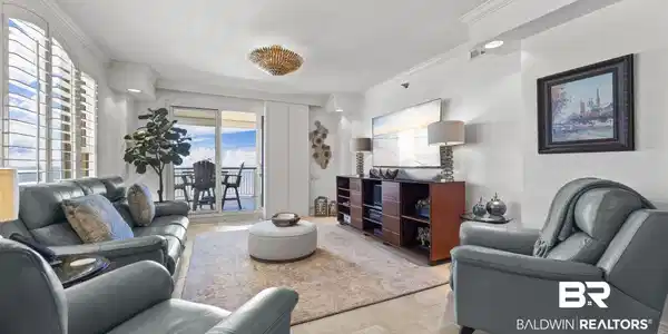 Image 4: Living area featuring a private balcony, arched plantation shutters, recessed lighting, crown molding, and tiled flooring