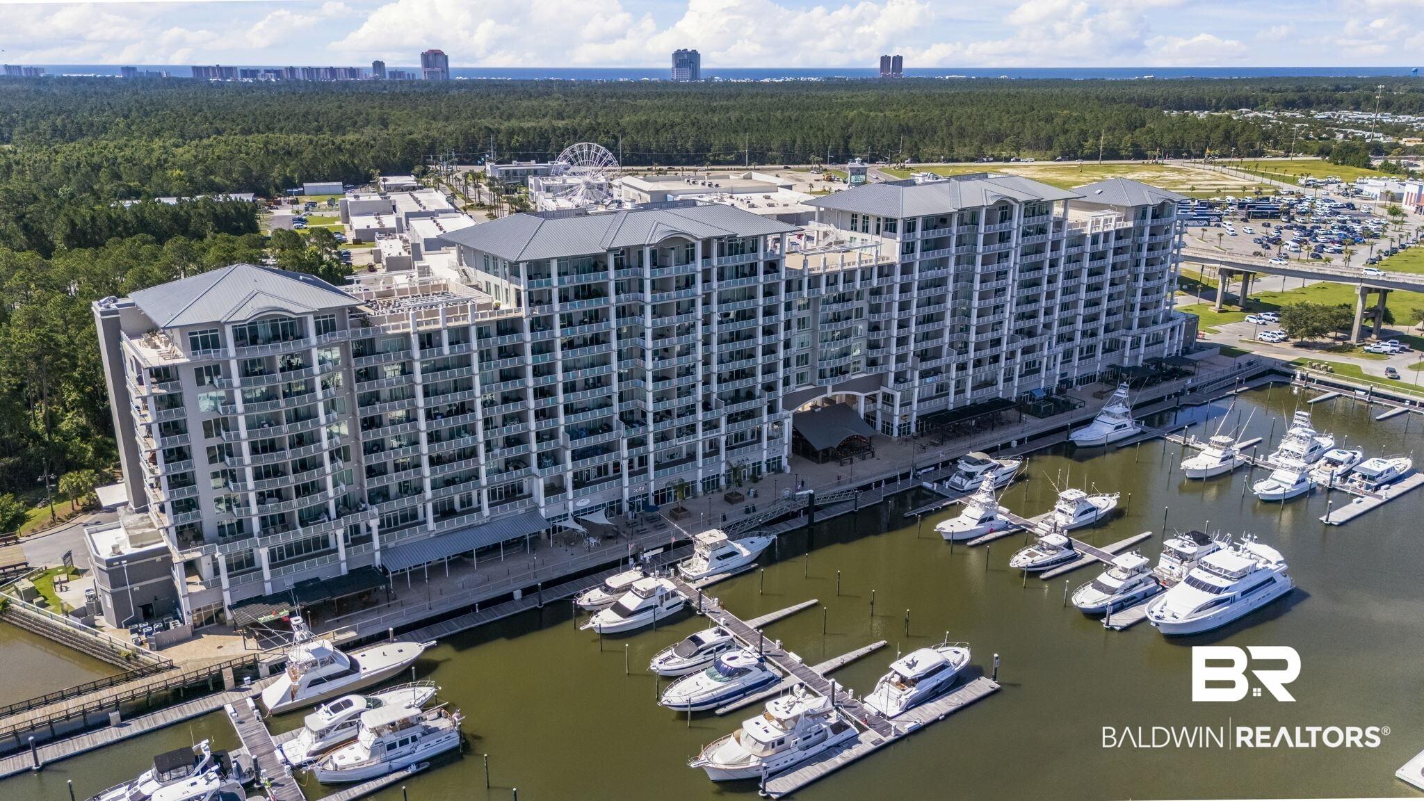 Image 3: Multi-story waterfront condominium building featuring private balconies and a ground-level marina
