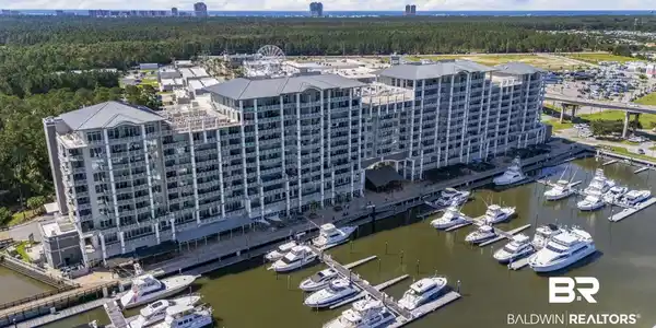 Image 3: Multi-story waterfront condominium building featuring private balconies and a ground-level marina
