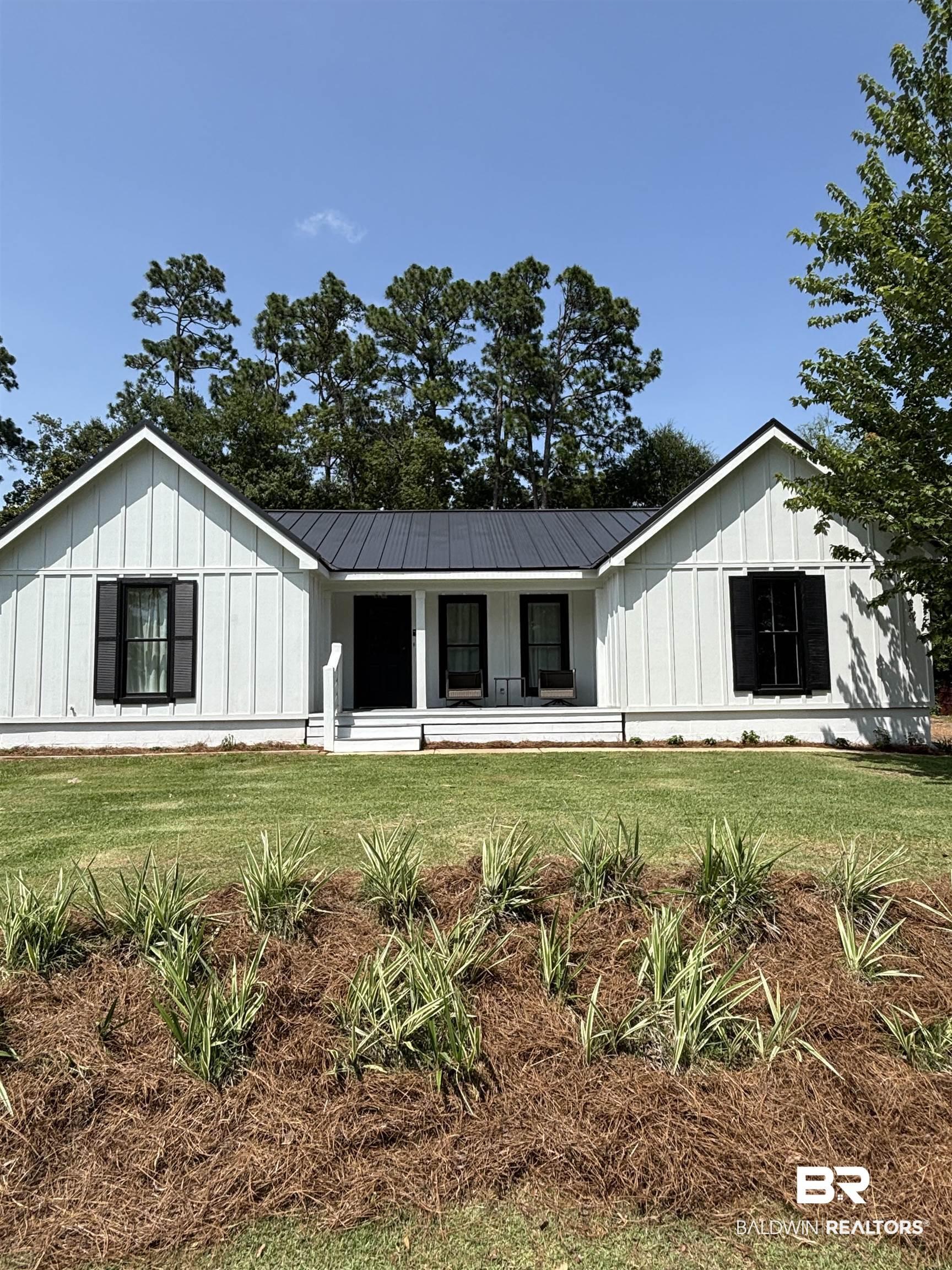Image 1: White board-and-batten siding with a dark metal roof