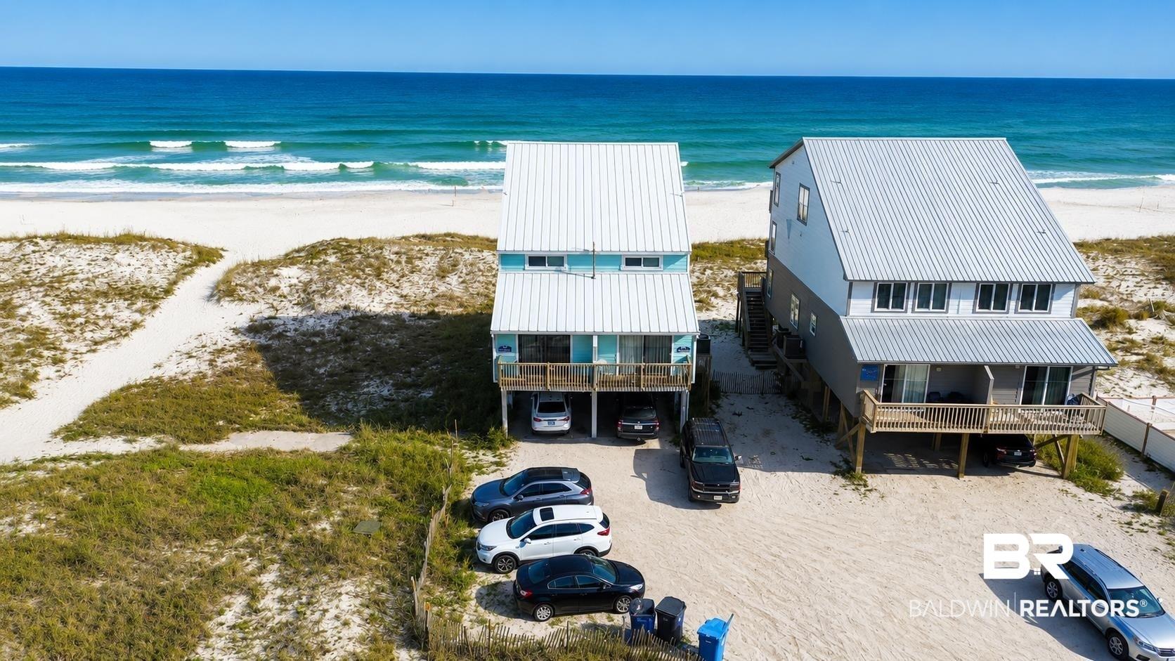 Image 1: Coastal home featuring a carport and dirt driveway