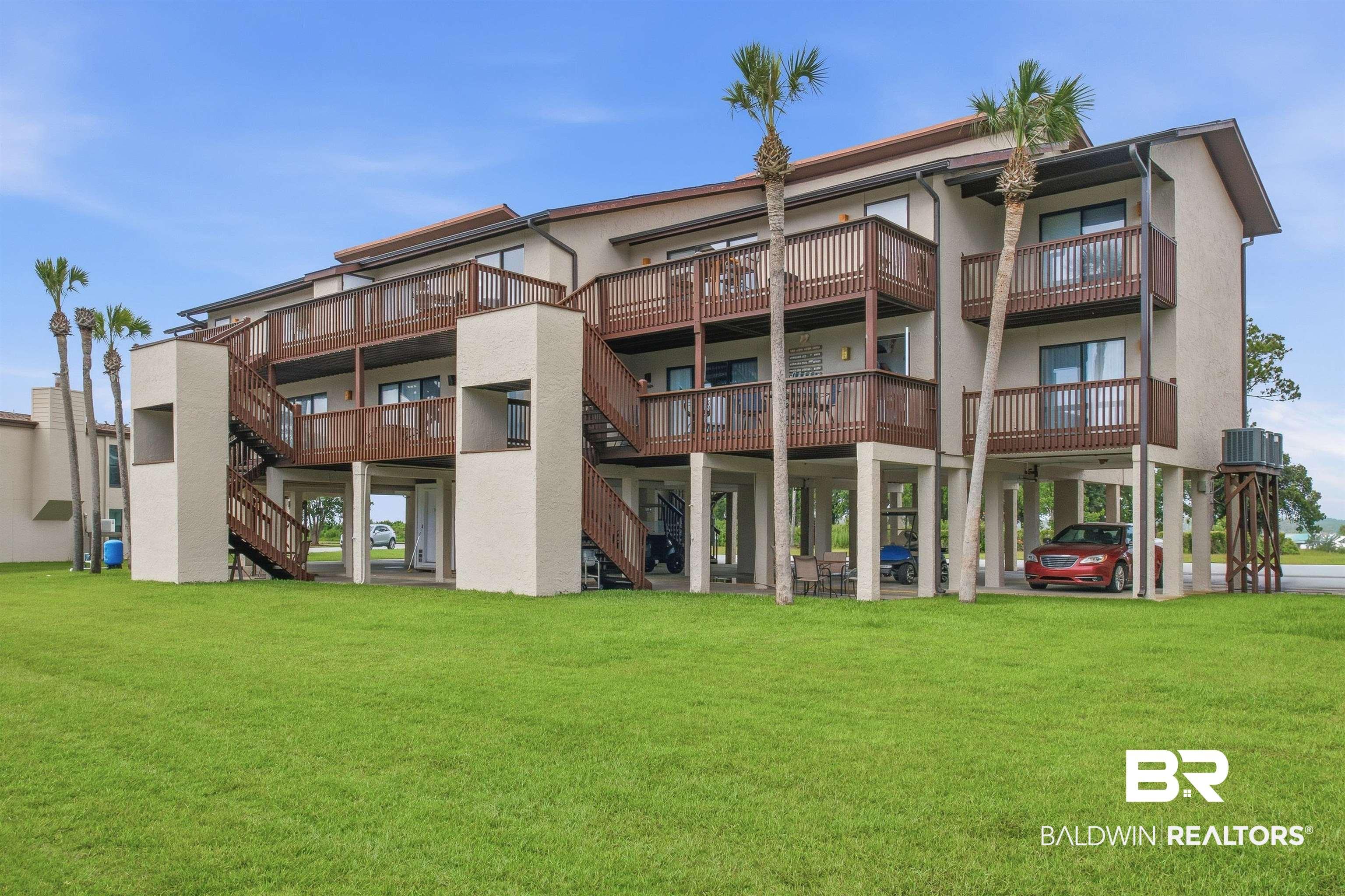 Image 1: Multi-story building featuring stucco exterior, multiple private balconies with wood railings, and exterior wood staircases