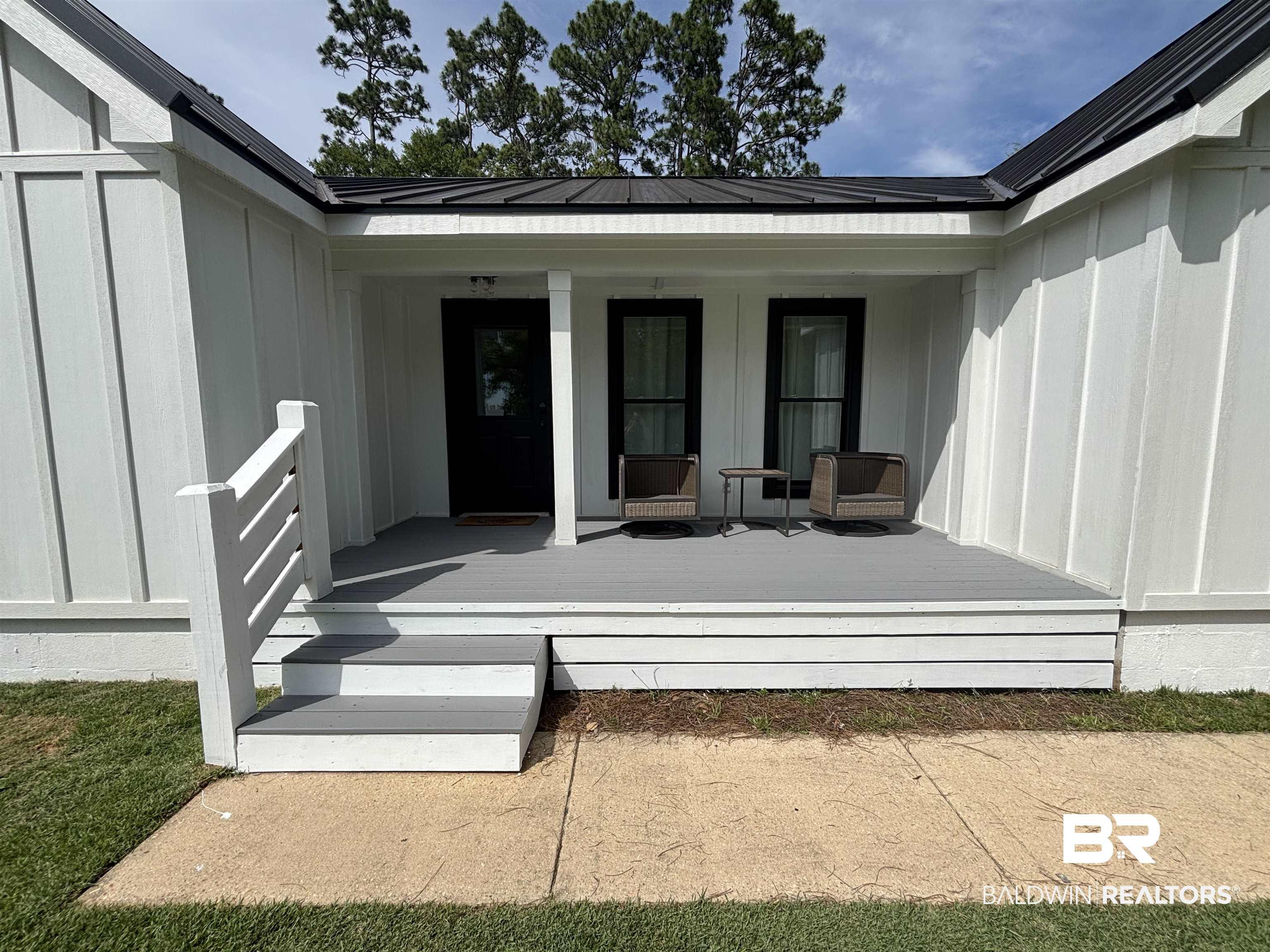 Image 4: Inviting front porch featuring a gray-toned deck, white railing, and steps
