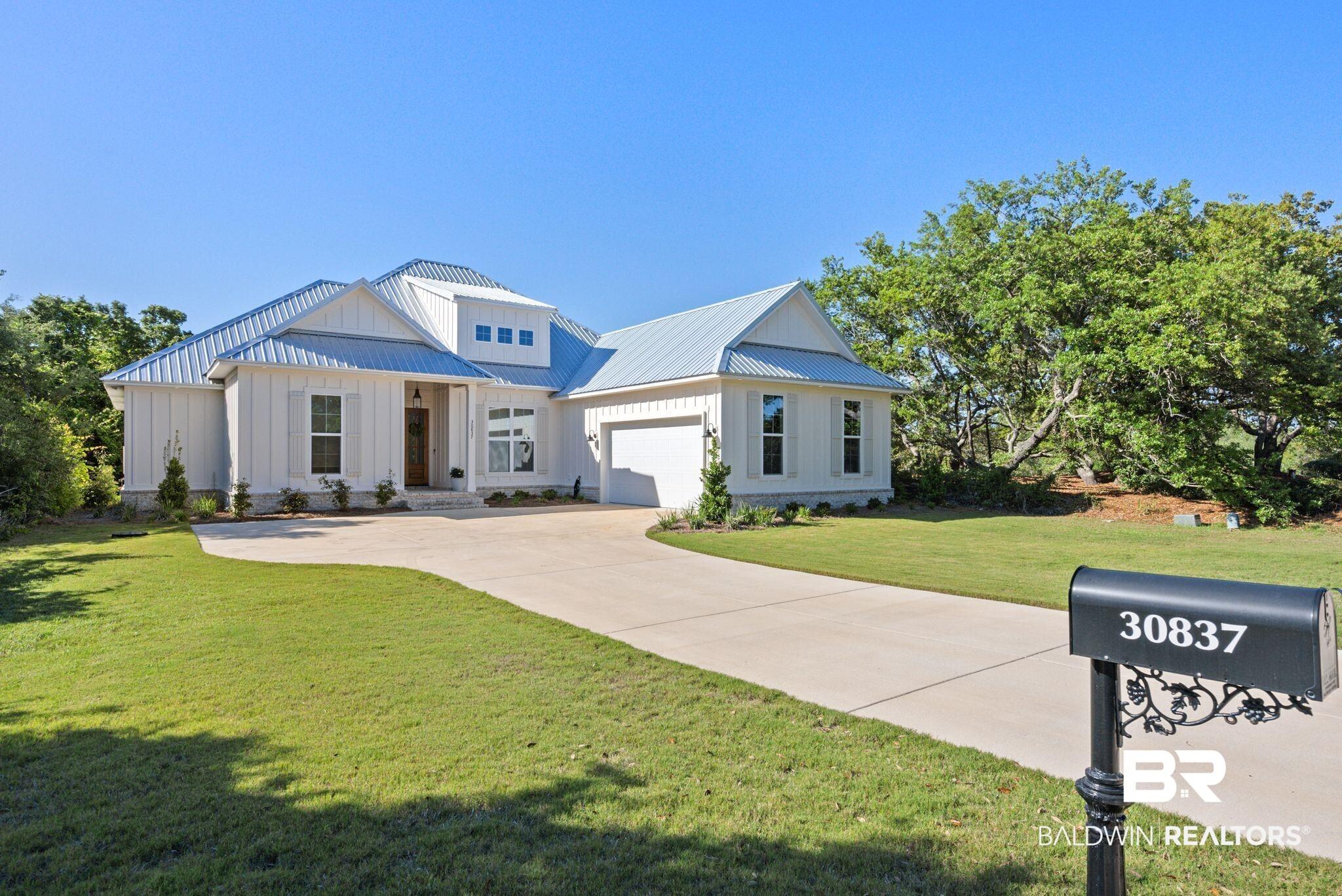 Image 2: Contemporary white exterior with vertical siding and a light-toned metal roof