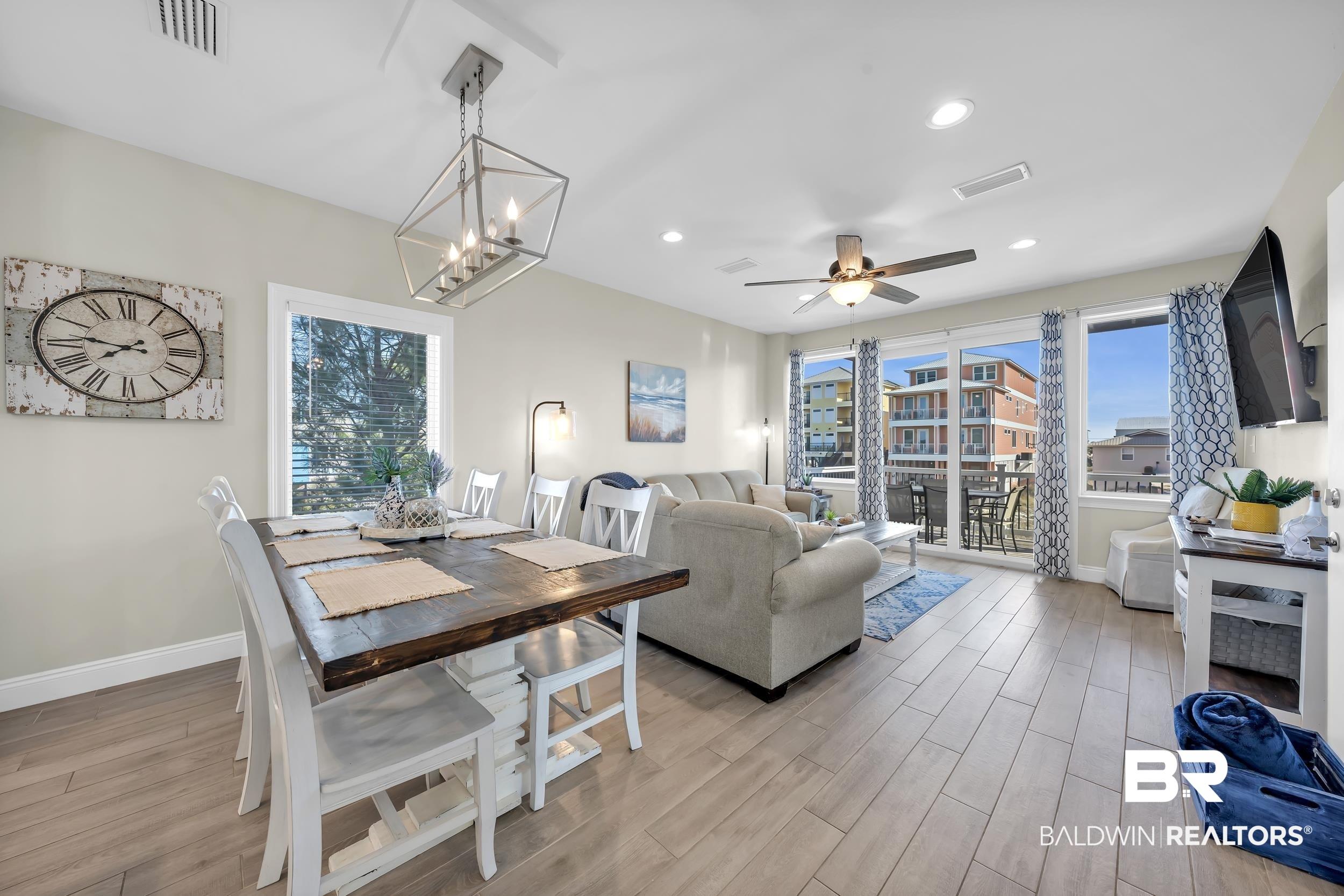 Image 3: Dining area featuring a ceiling fan, light wood finished floors, and hanging lights