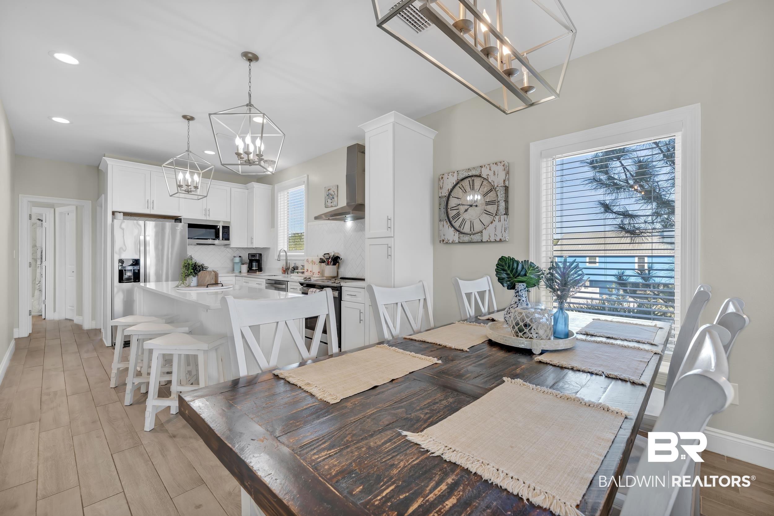 Image 4: Dining space featuring suspended lighting and light wood-style floors