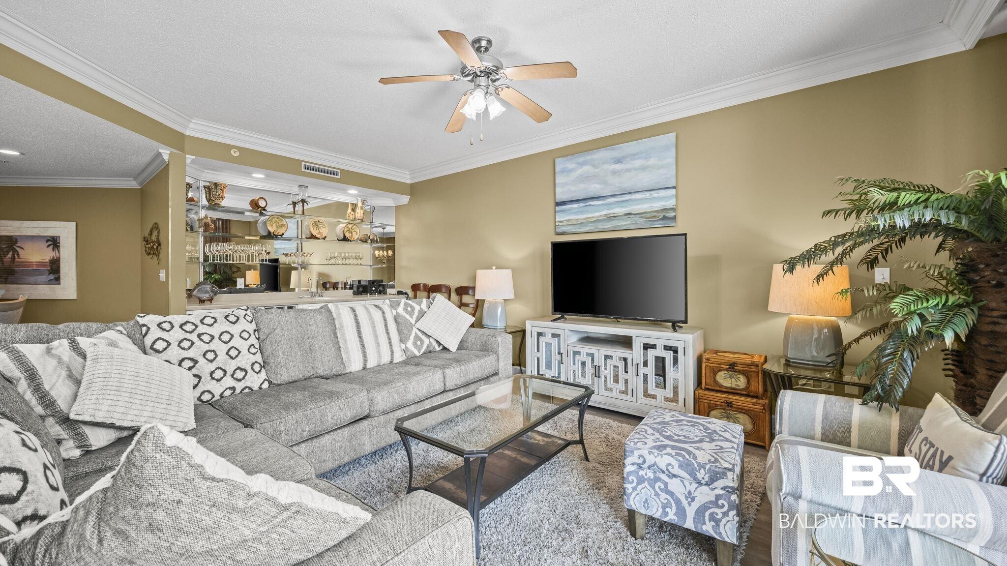 Image 3: Living area featuring ornamental molding and a ceiling fan