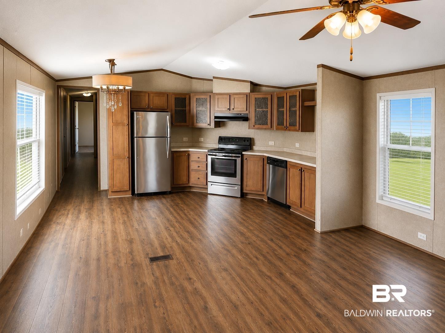 Image 3: Open-concept kitchen and living area featuring wood-finish flooring, recessed lighting, and a ceiling fan with light fixture