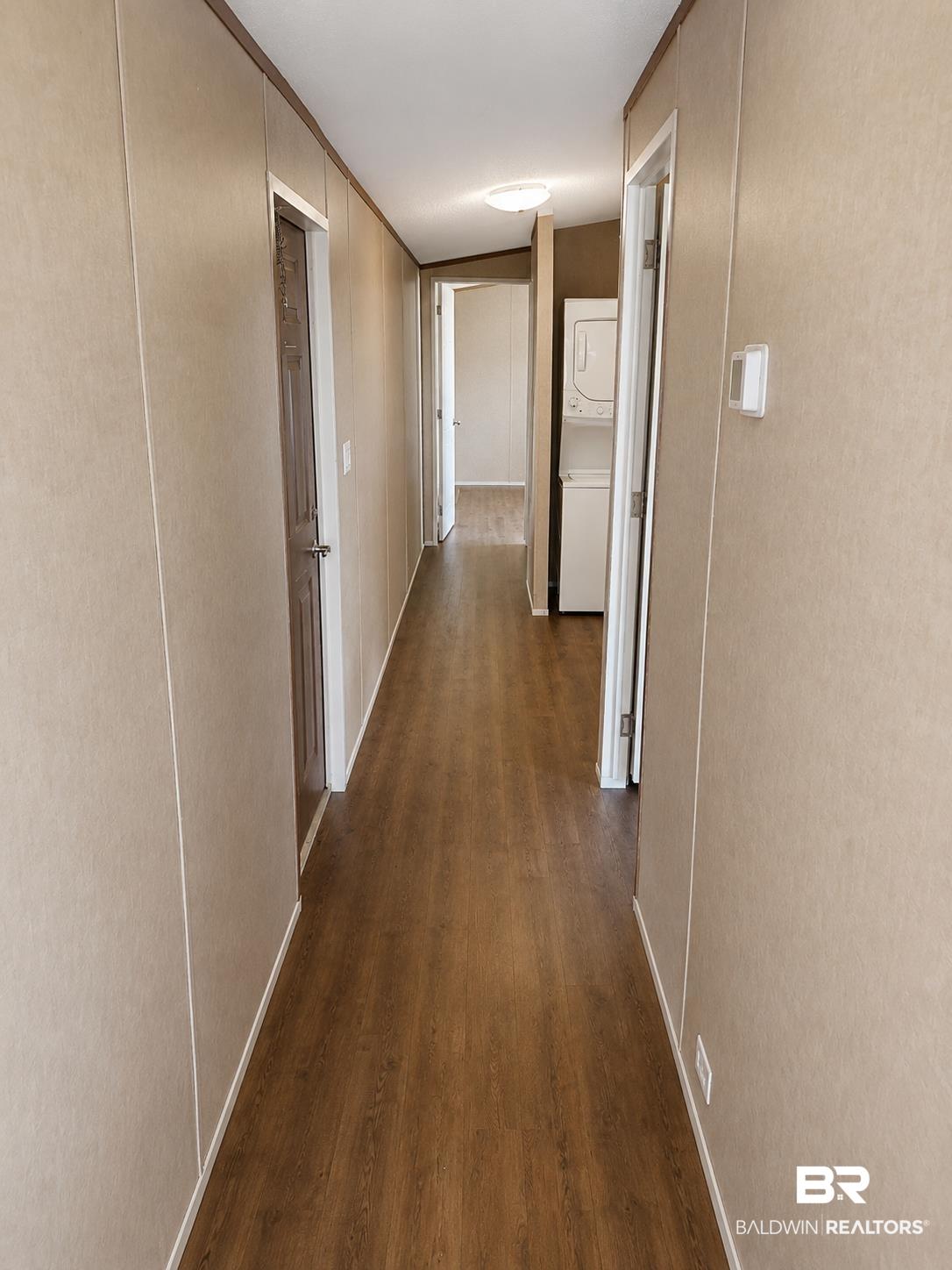 Image 4: Hallway featuring wood-finish flooring, light-toned wall panels, and white trim