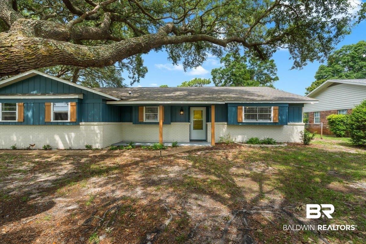 Image 4: Ranch-style exterior with a white brick facade and teal siding