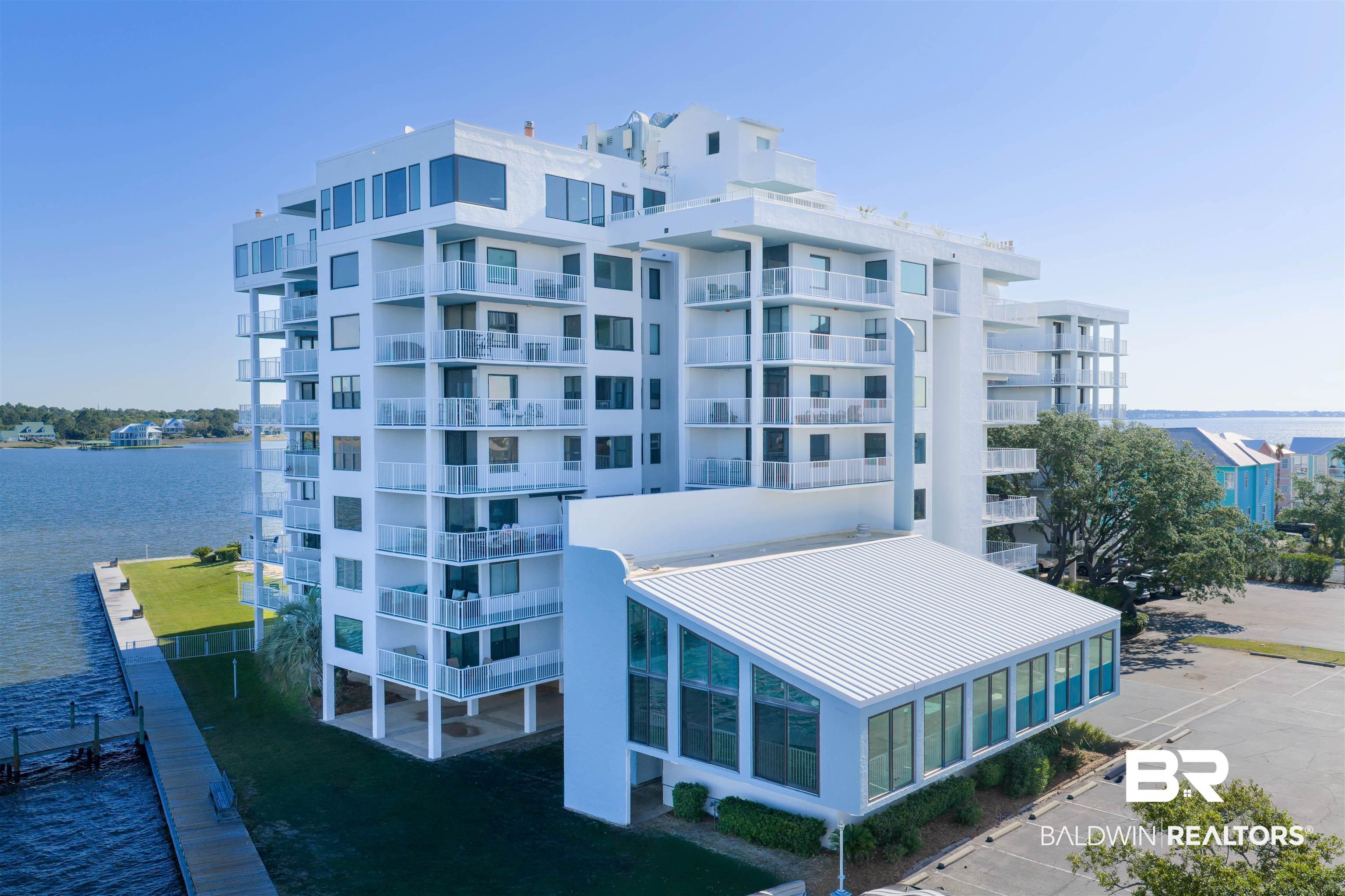 Image 3: Modern multi-story building featuring multiple private balconies, extensive window placements, and a white exterior finish