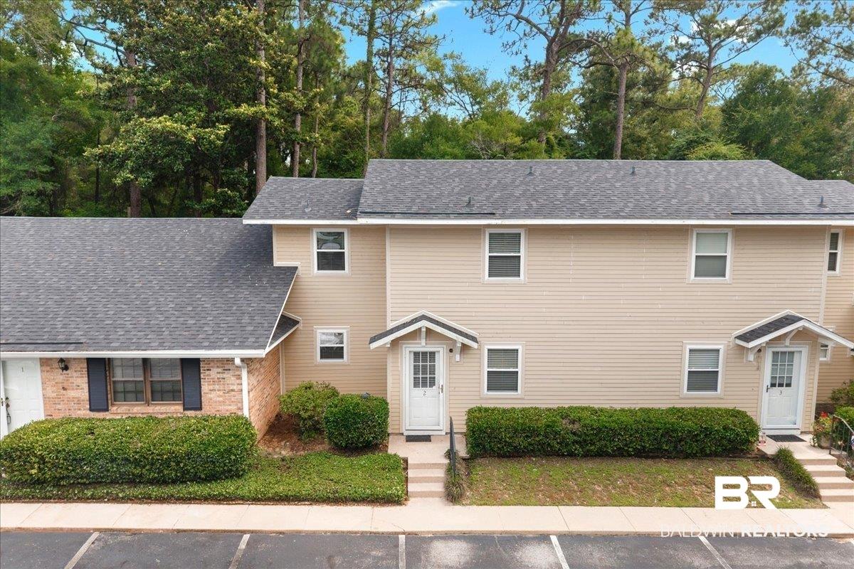 Image 1: Multi-unit property featuring tan siding and brick accents
