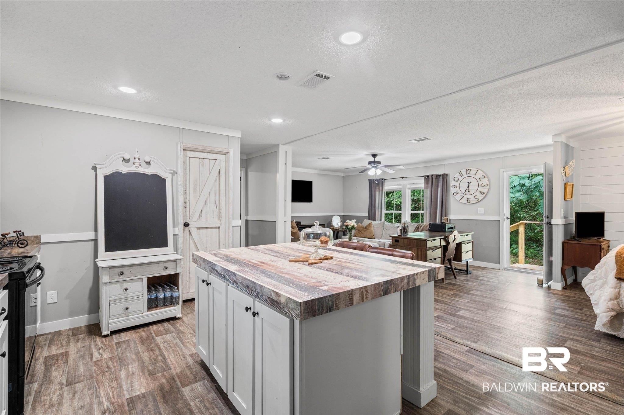 Image 3: Open-concept living space with wood-finish flooring throughout
