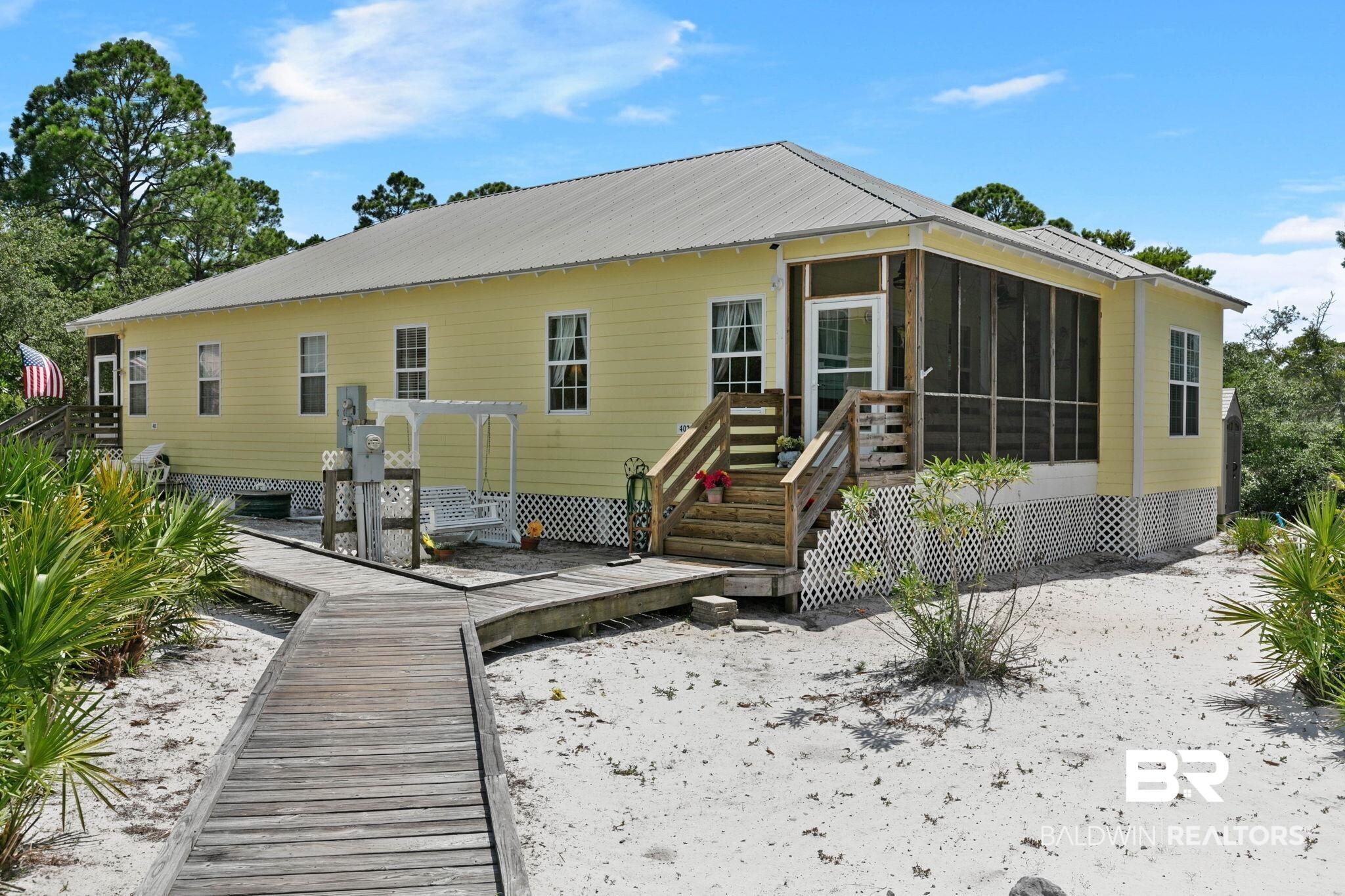 Image 1: Single-story yellow exterior with a metal roof