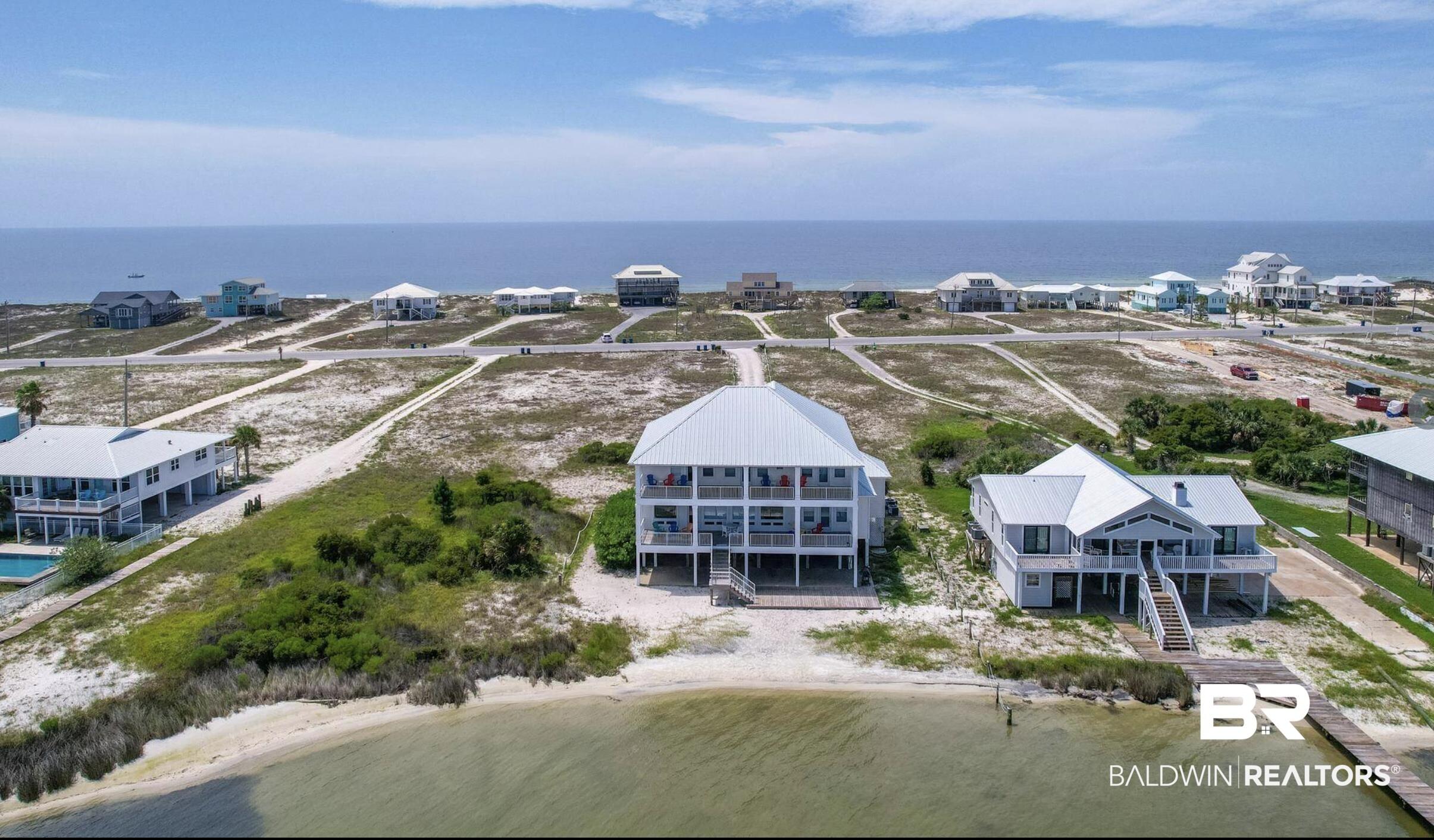 Image 1: Elevated coastal residence featuring a multi-level deck, direct beach access, and a private dock