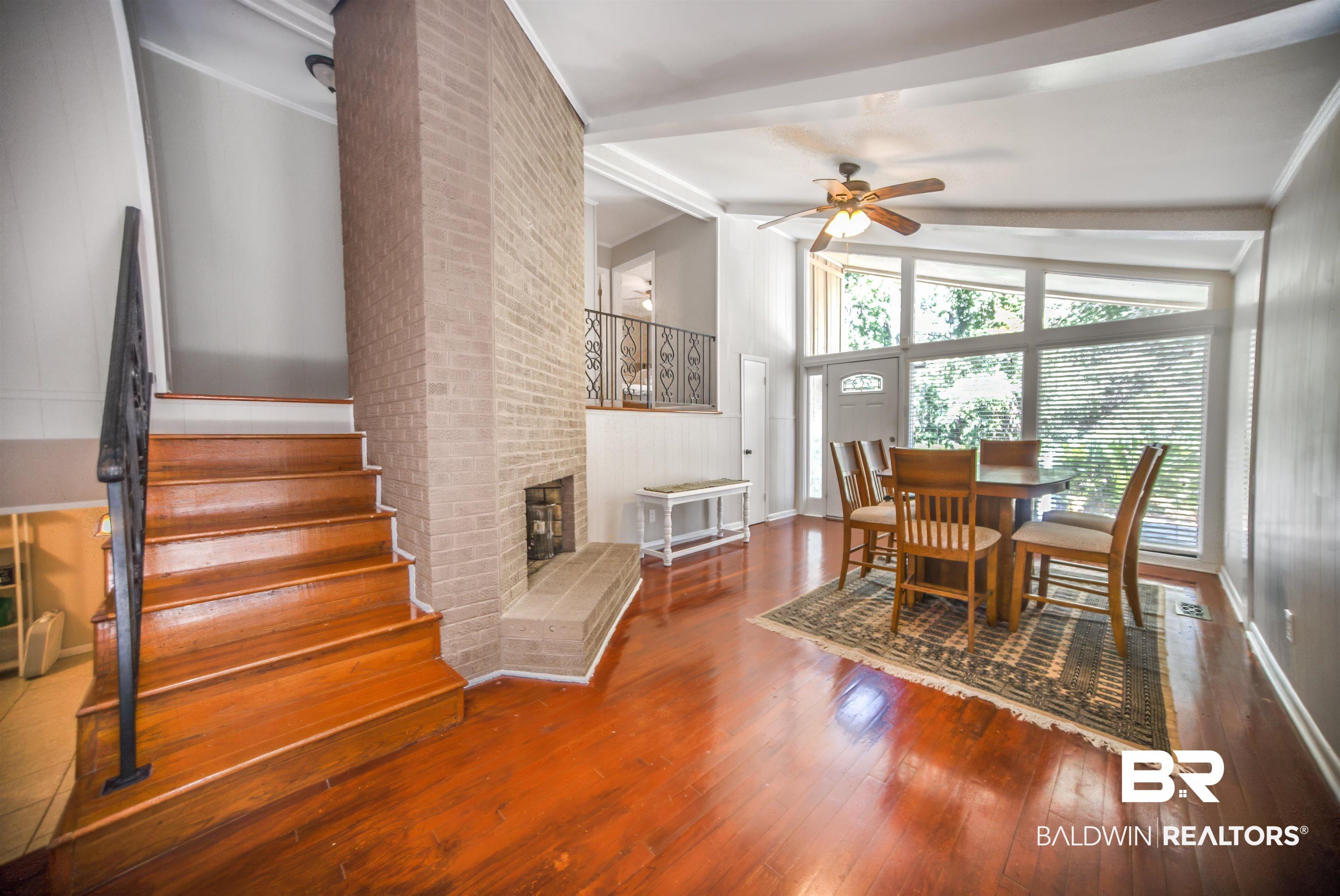 Image 4: Living space featuring wood-finish flooring and a brick fireplace
