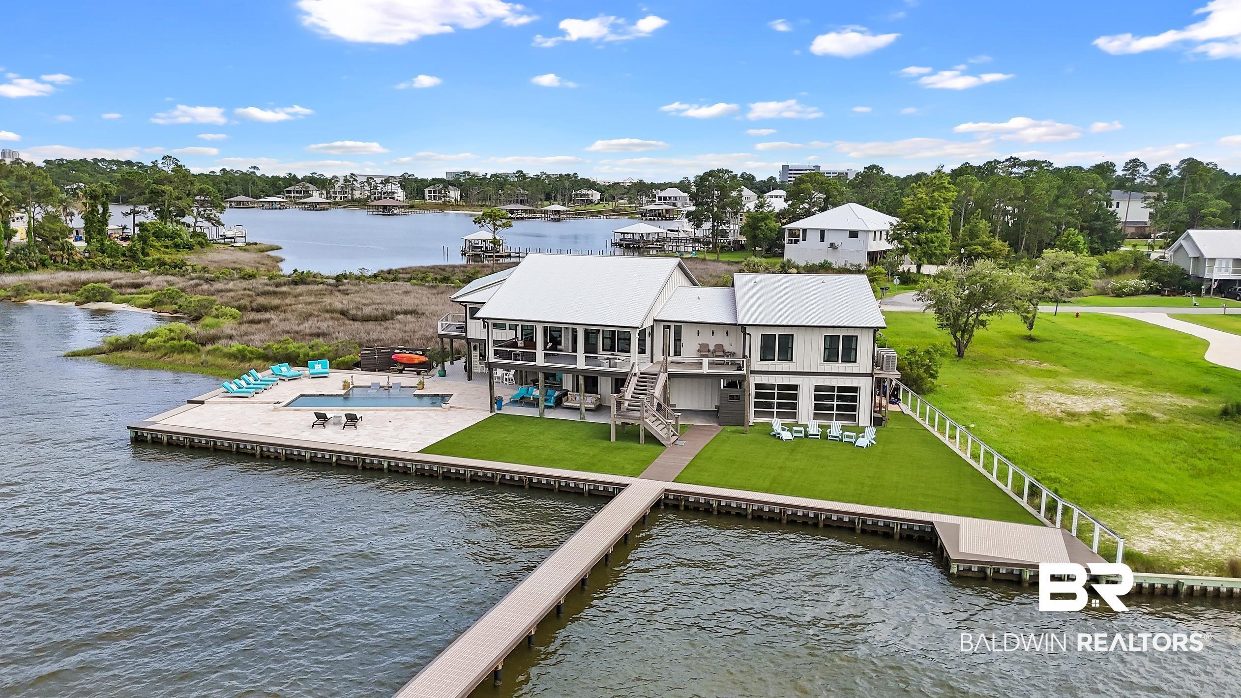 Image 2: Waterfront residence featuring a private dock, expansive deck, and a sparkling pool