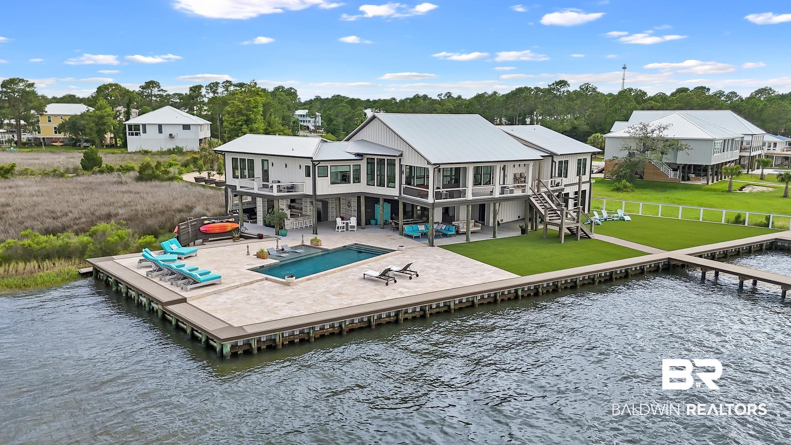 Image 4: Waterfront residence featuring a private pool and expansive paved patio