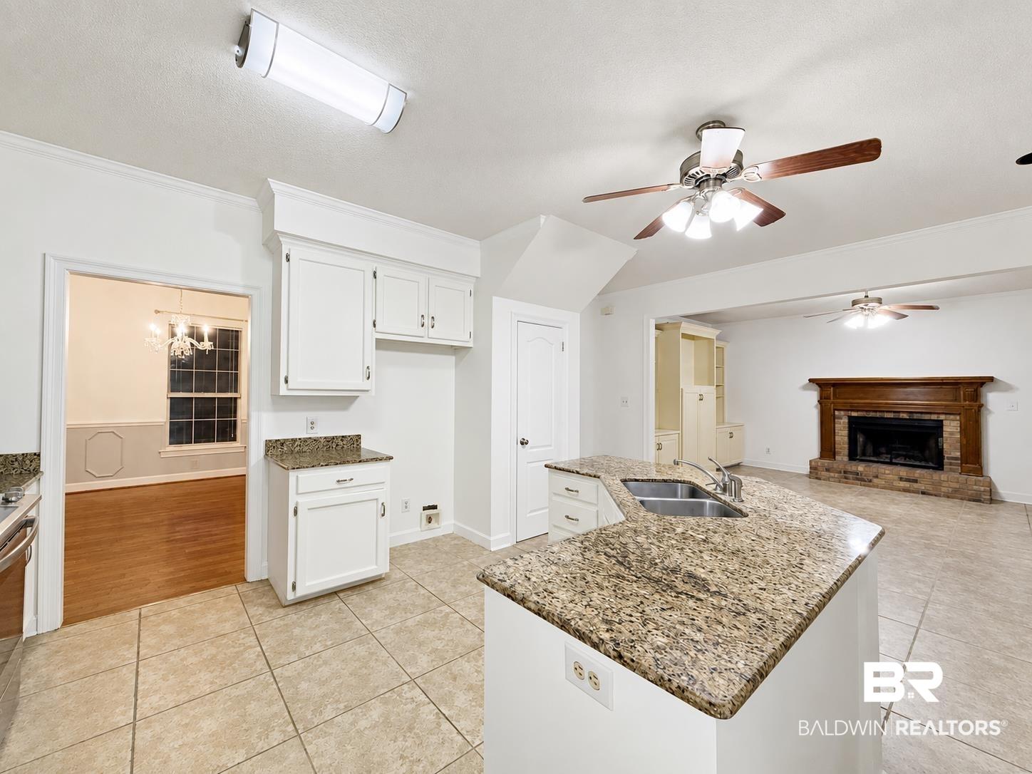 Image 3: Kitchen featuring a peninsula with integrated double basin sink and granite-finish countertops
