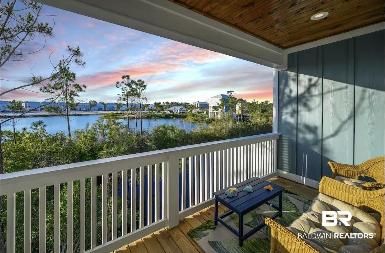 Image 2: Covered balcony with natural wood ceiling, recessed lighting, white balustrade, and wood-finish flooring