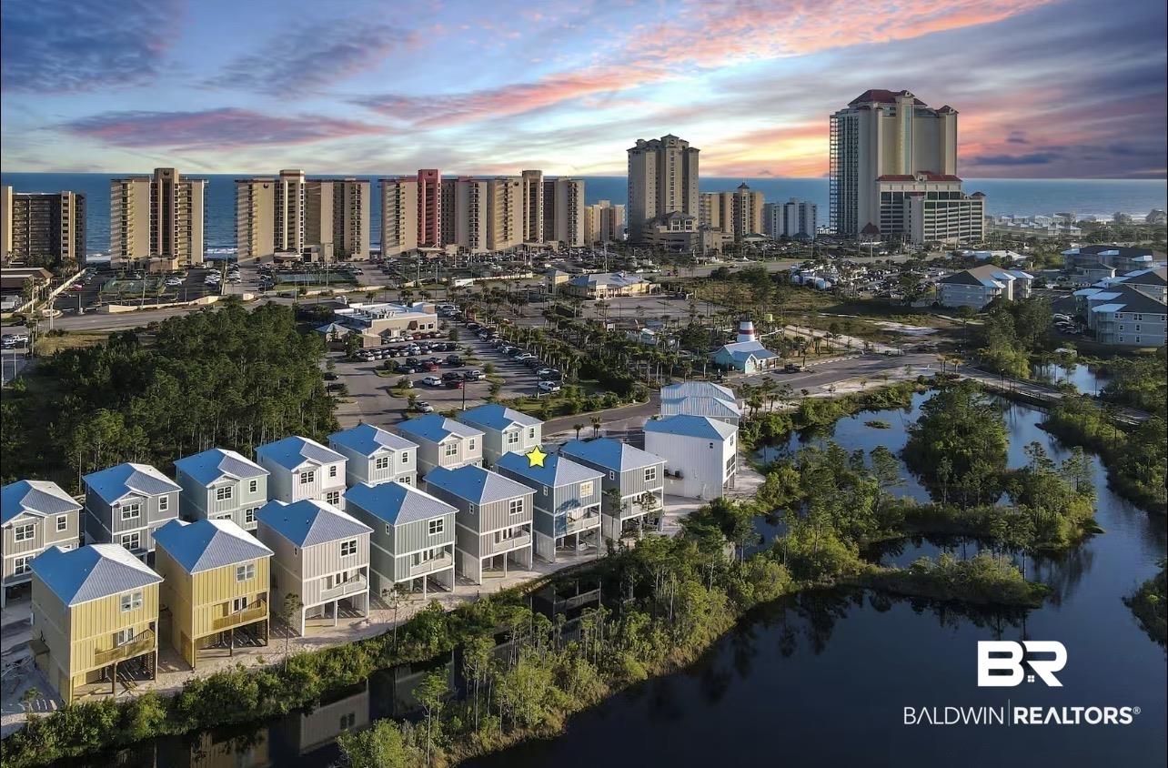 Image 3: Aerial perspective showcasing a row of elevated properties with light-colored siding and white roofs