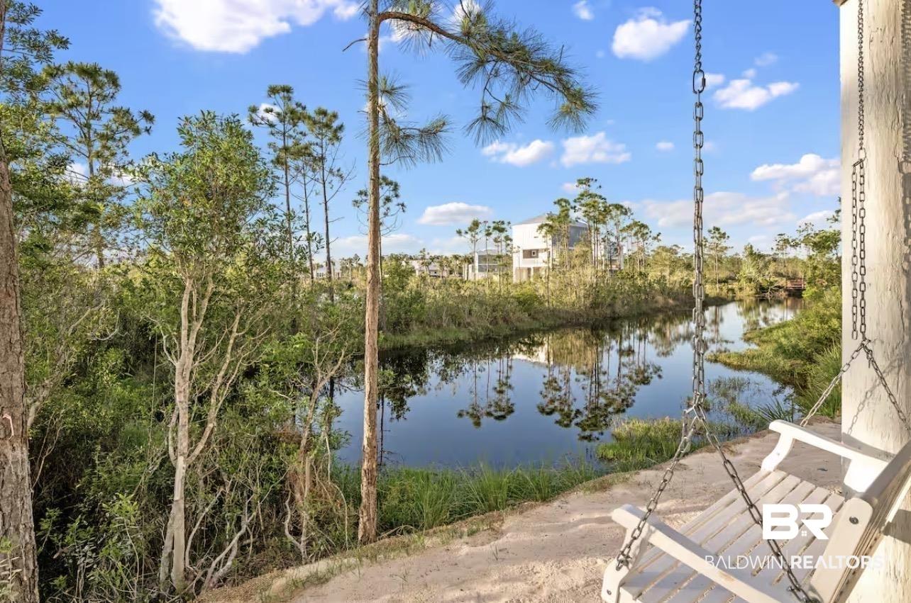 Image 4: Waterfront setting featuring a natural landscape and a white porch swing