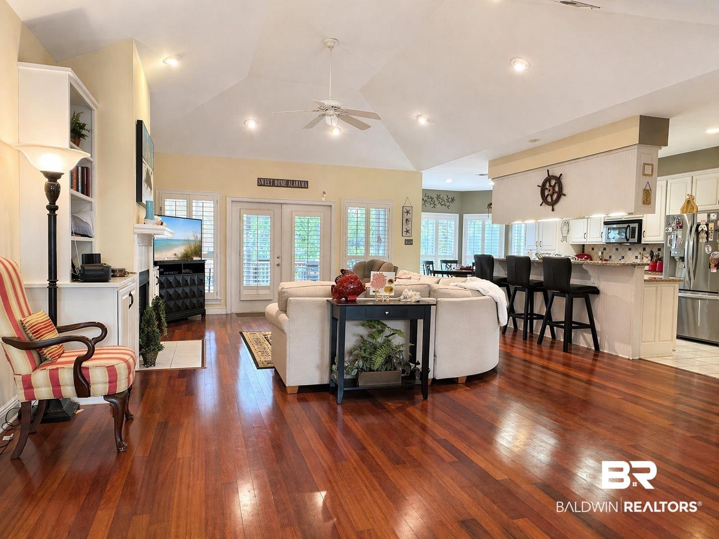 Image 3: Living area featuring light wood-type flooring, a ceiling fan, lofted ceiling, recessed lighting, and french doors