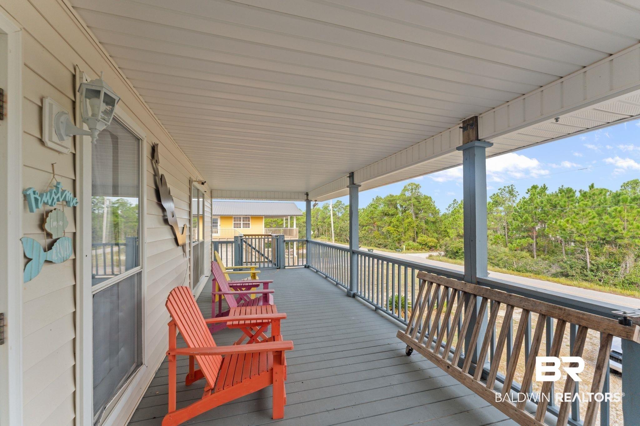 Image 4: Expansive covered porch featuring a painted wood-finish floor, white soffit ceiling, and support columns