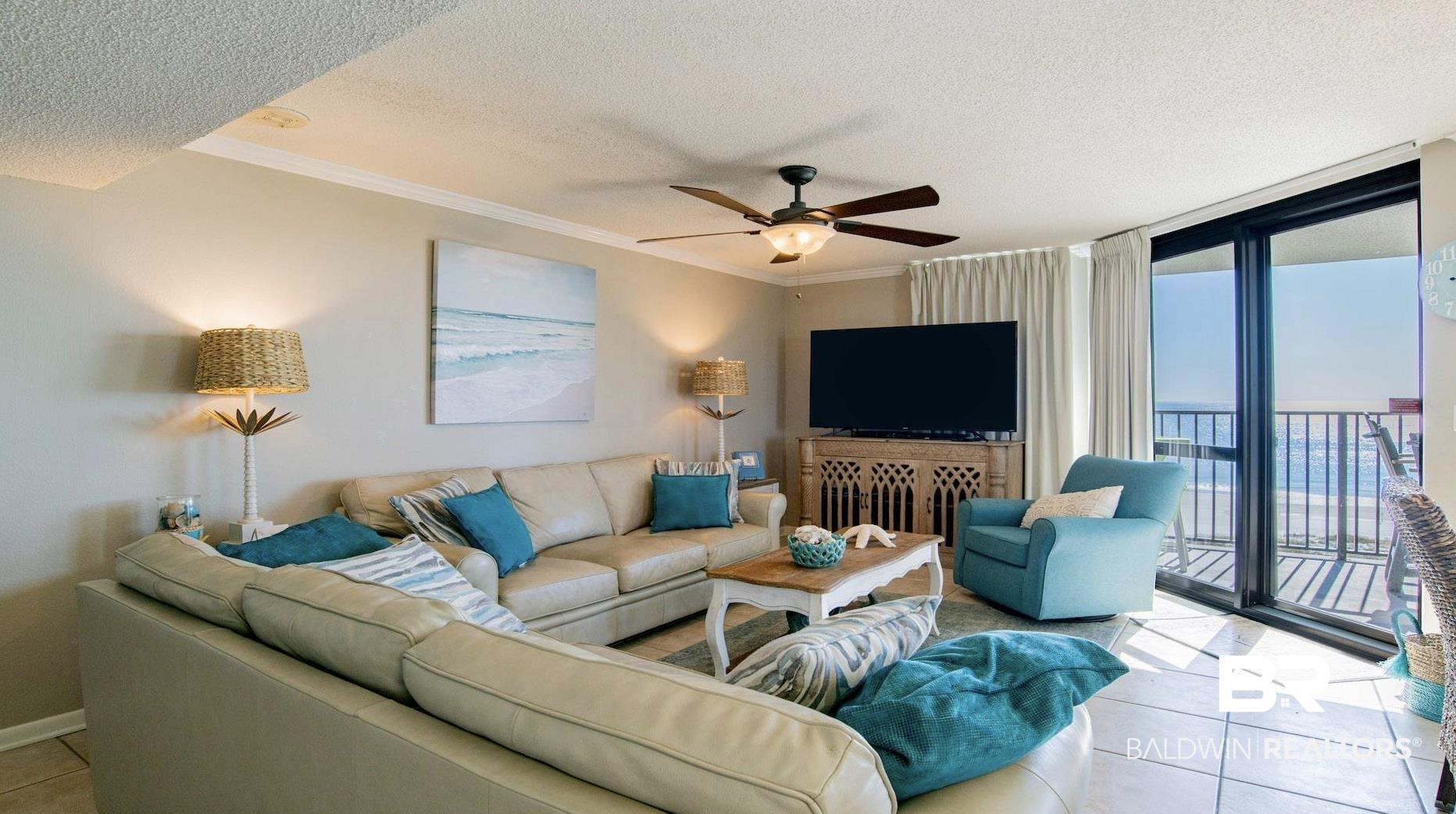 Image 2: Living area featuring large format tile flooring, a ceiling fan with integrated lighting, and crown molding