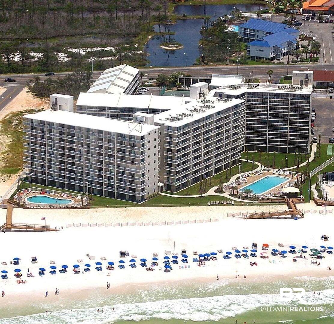 Image 1: Multi-story condominium buildings fronting a white sand beach