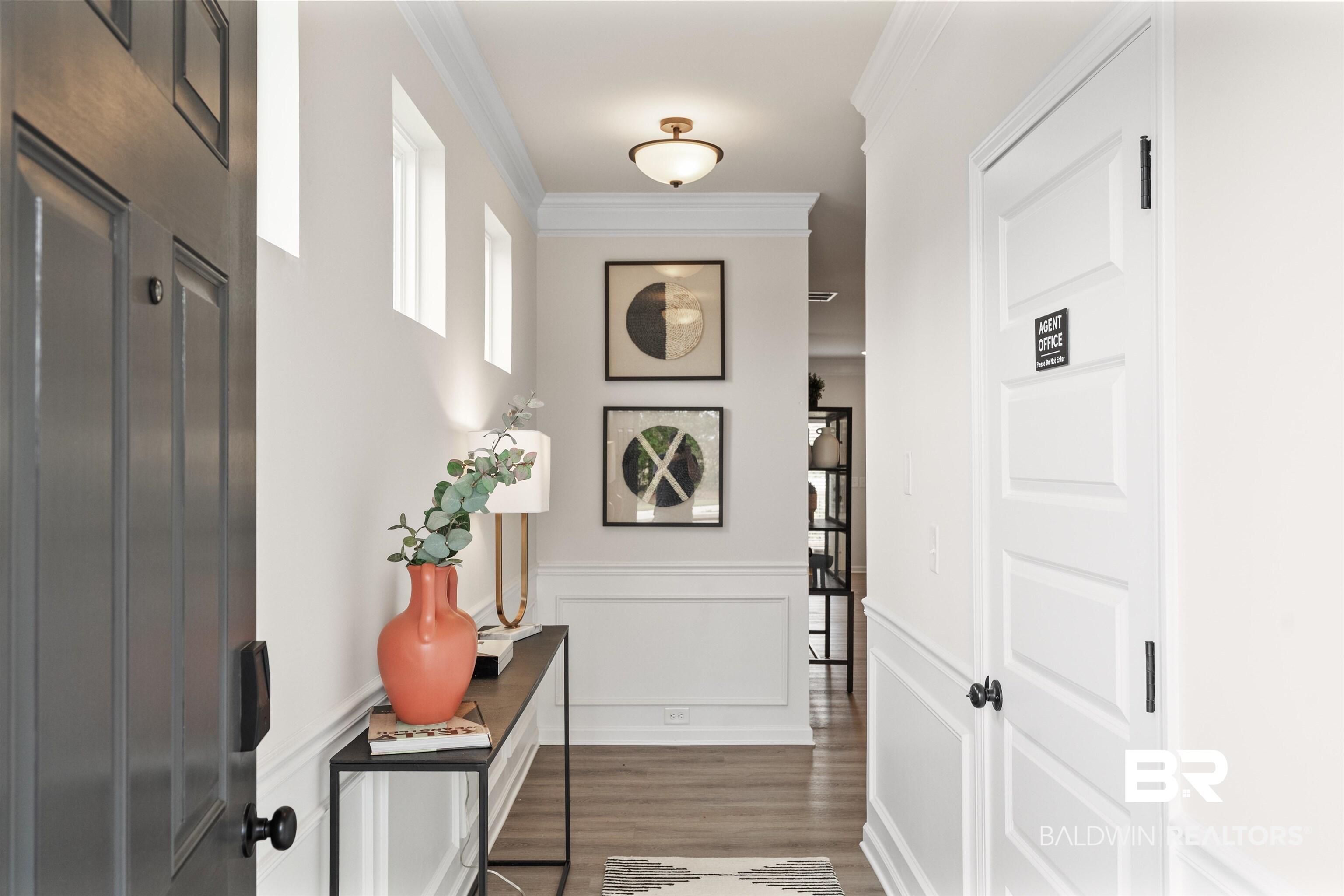 Image 4: Entryway featuring wood-finish flooring, wainscoting, crown molding, and recessed wall windows
