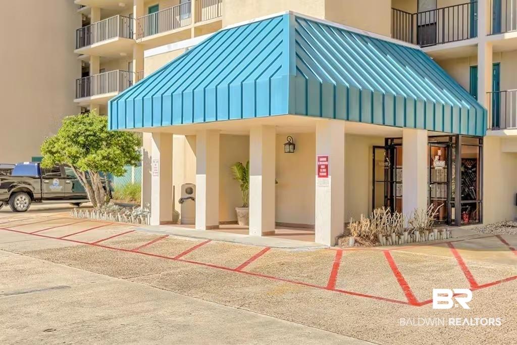 Image 2: Building entrance featuring a prominent blue metal awning