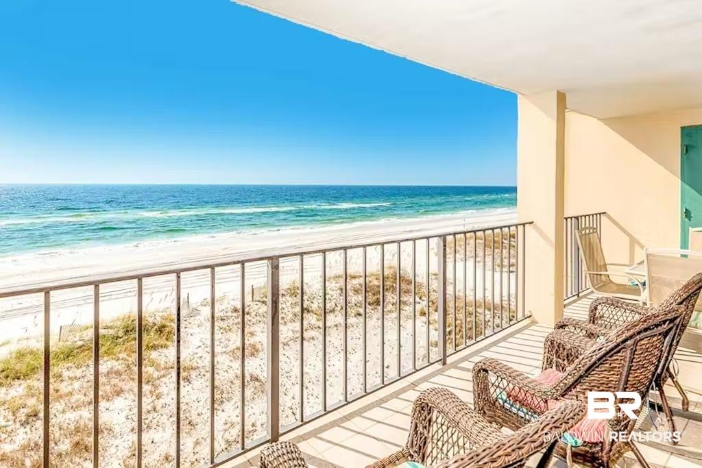 Image 3: Expansive private balcony featuring a metal railing, direct beach access, and panoramic ocean scenery