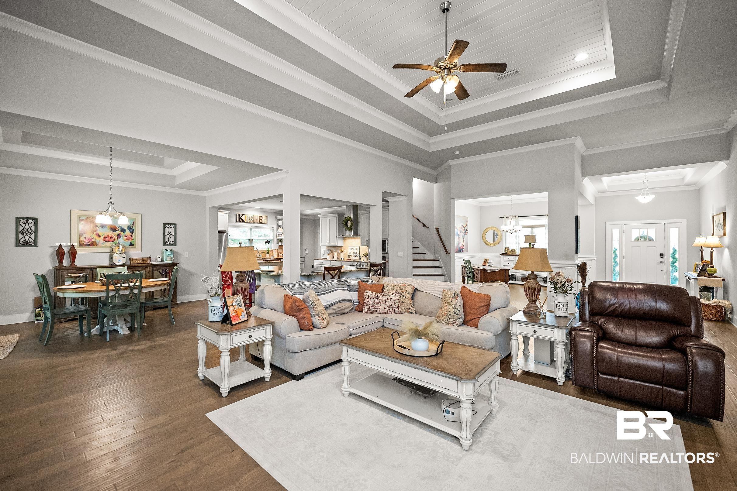Image 4: Expansive living area featuring coffered ceilings, wood-finish flooring, and recessed lighting