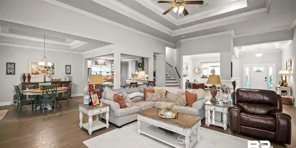 Image 4: Expansive living area featuring coffered ceilings, wood-finish flooring, and recessed lighting