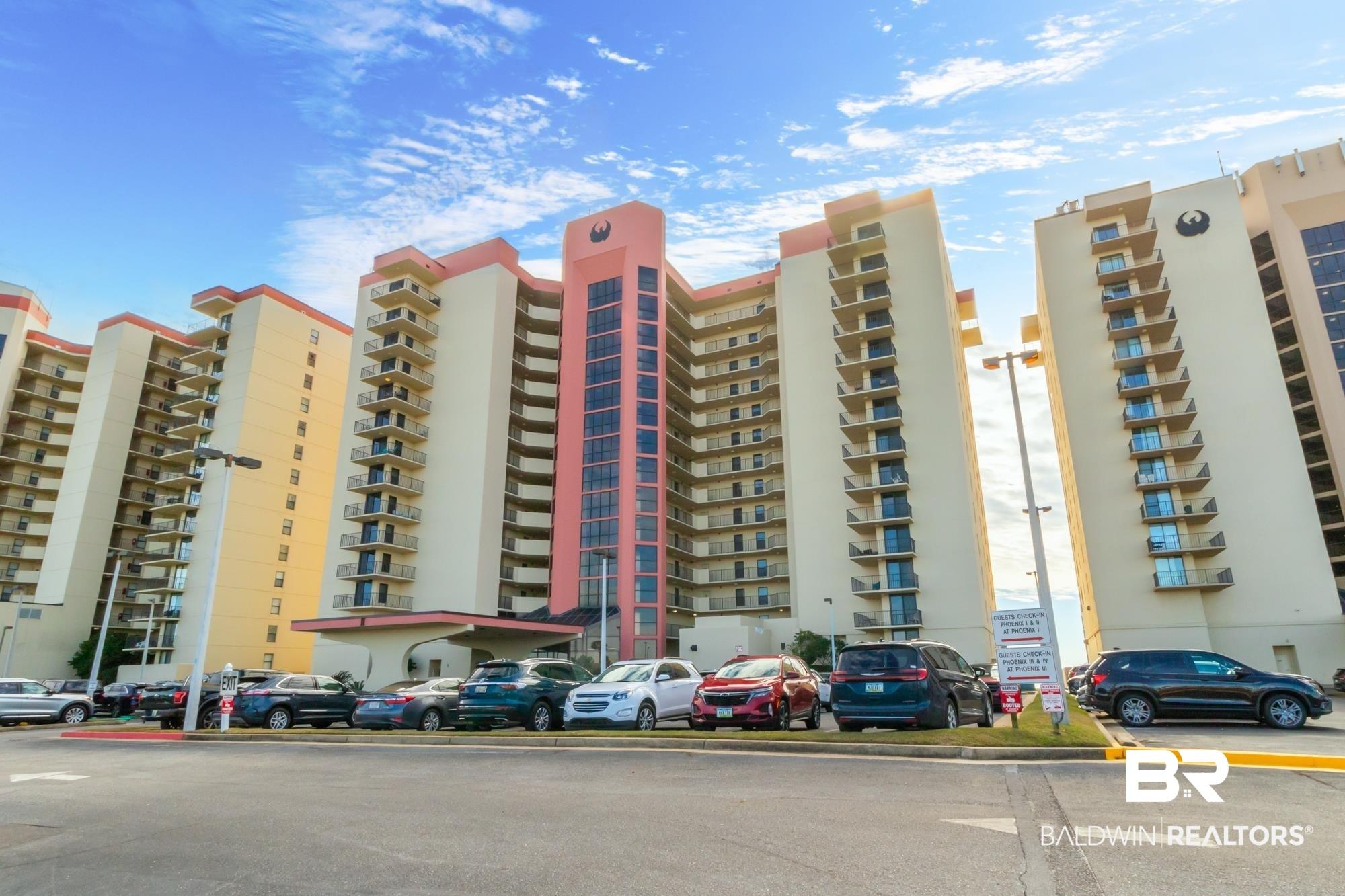 Image 3: Multi-story building featuring individual balconies, a covered porte-cochere entrance, and a parking area