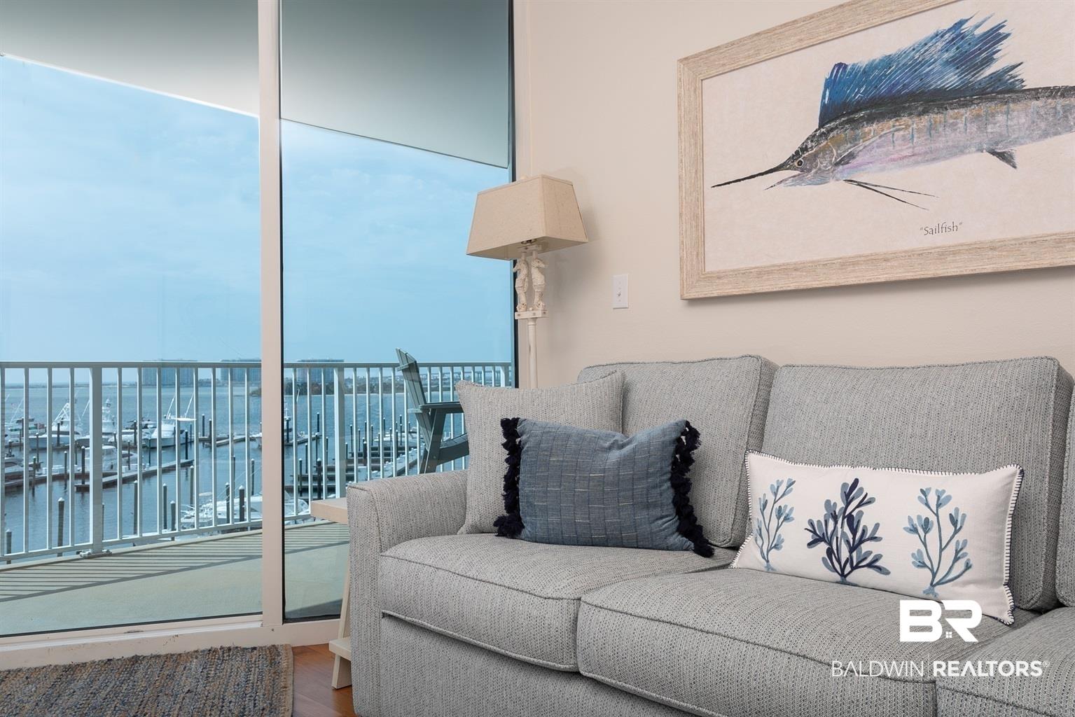 Image 4: Floor-to-ceiling glass sliding doors open to a balcony with a marina panorama