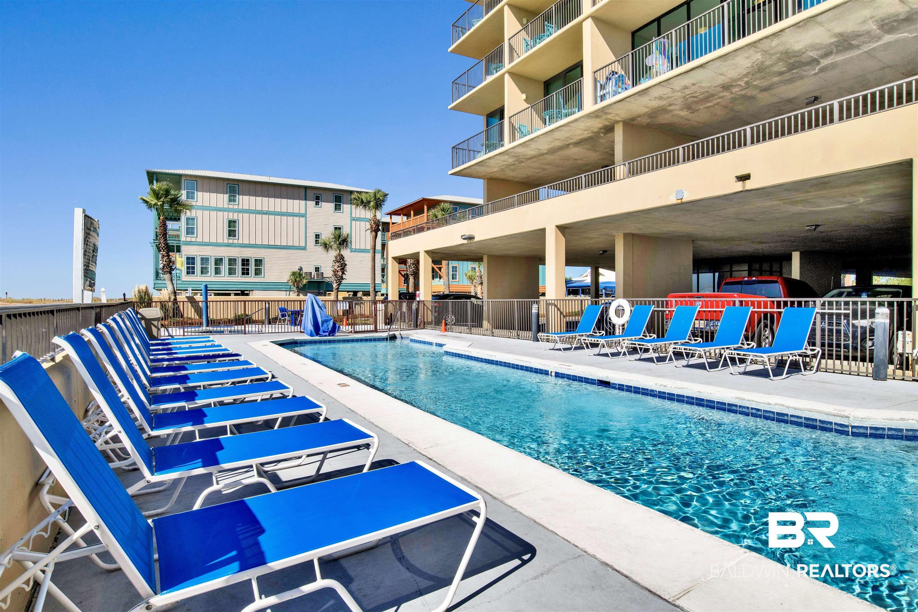Image 3: Outdoor swimming pool with integrated lounge seating area, surrounded by a concrete deck