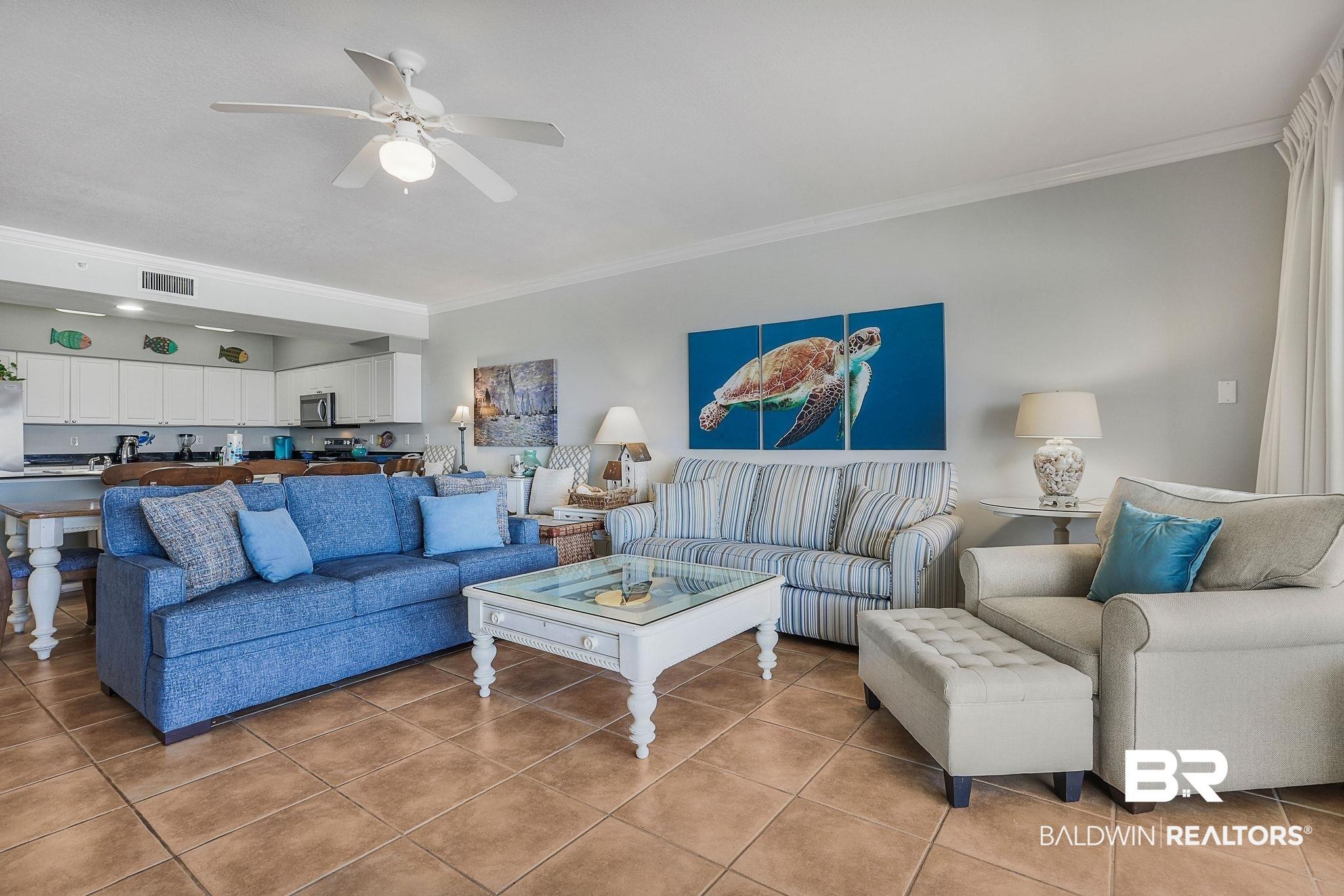 Image 4: Living area with crown molding, ceiling fan, and tile patterned floors