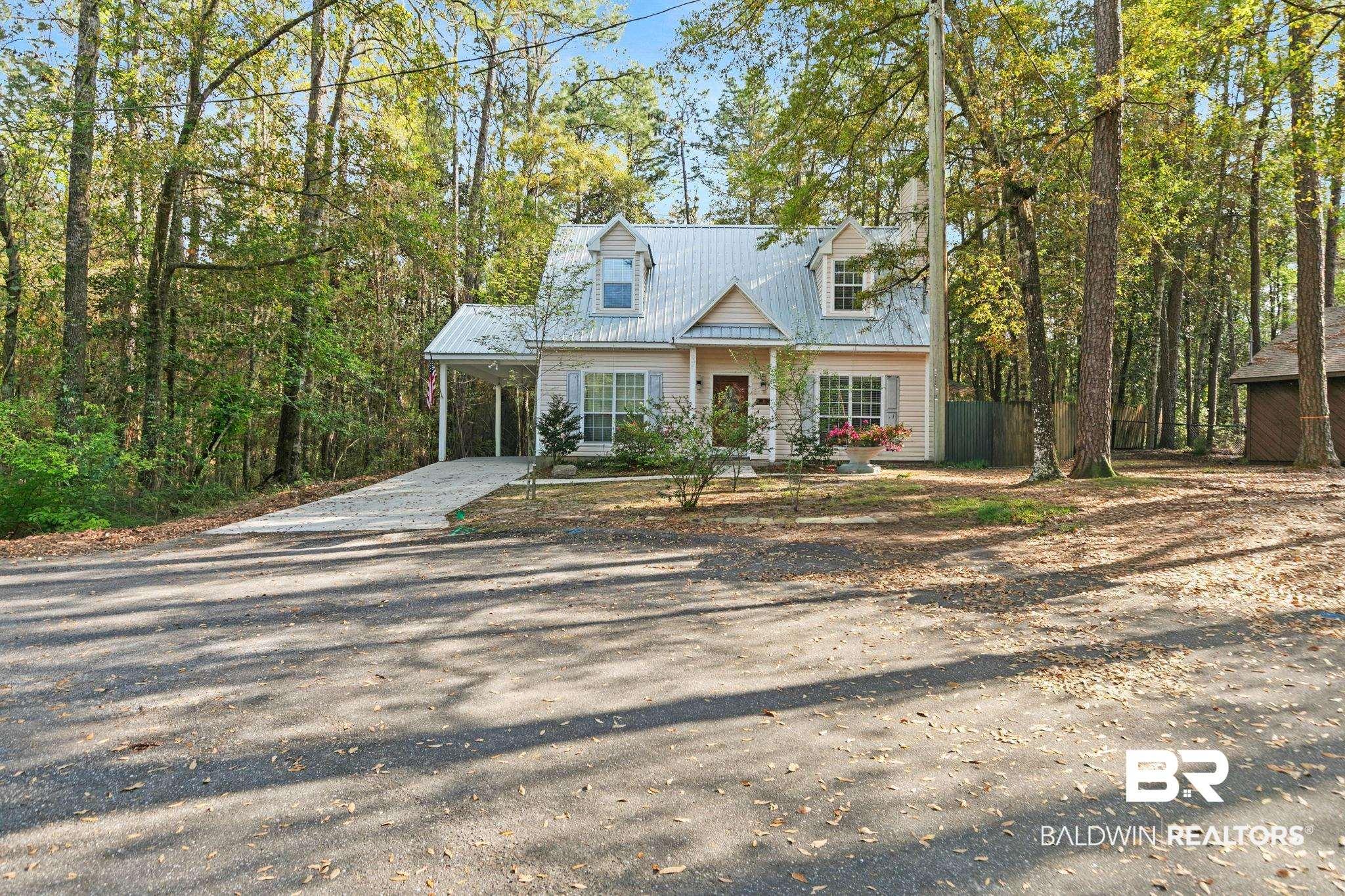 Image 1: New england style home featuring driveway, a carport, a porch, and a metal roof